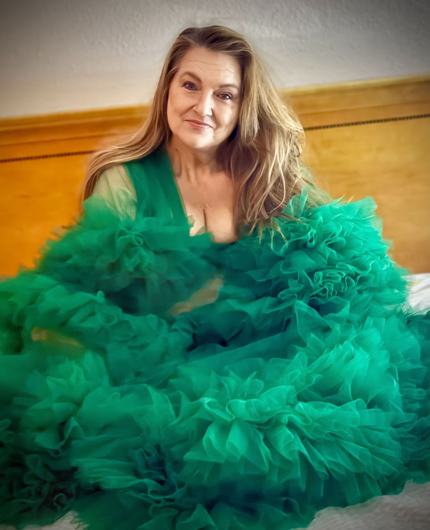 A lovely woman wearing an emerald green tulle dress twirls and poses playfully in photos