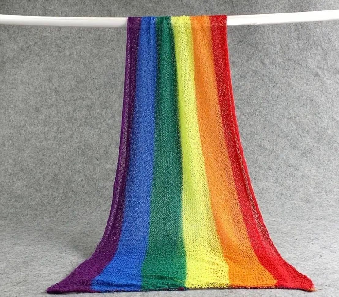 A rainbow colored knit scarf gradually unraveling into individual strands