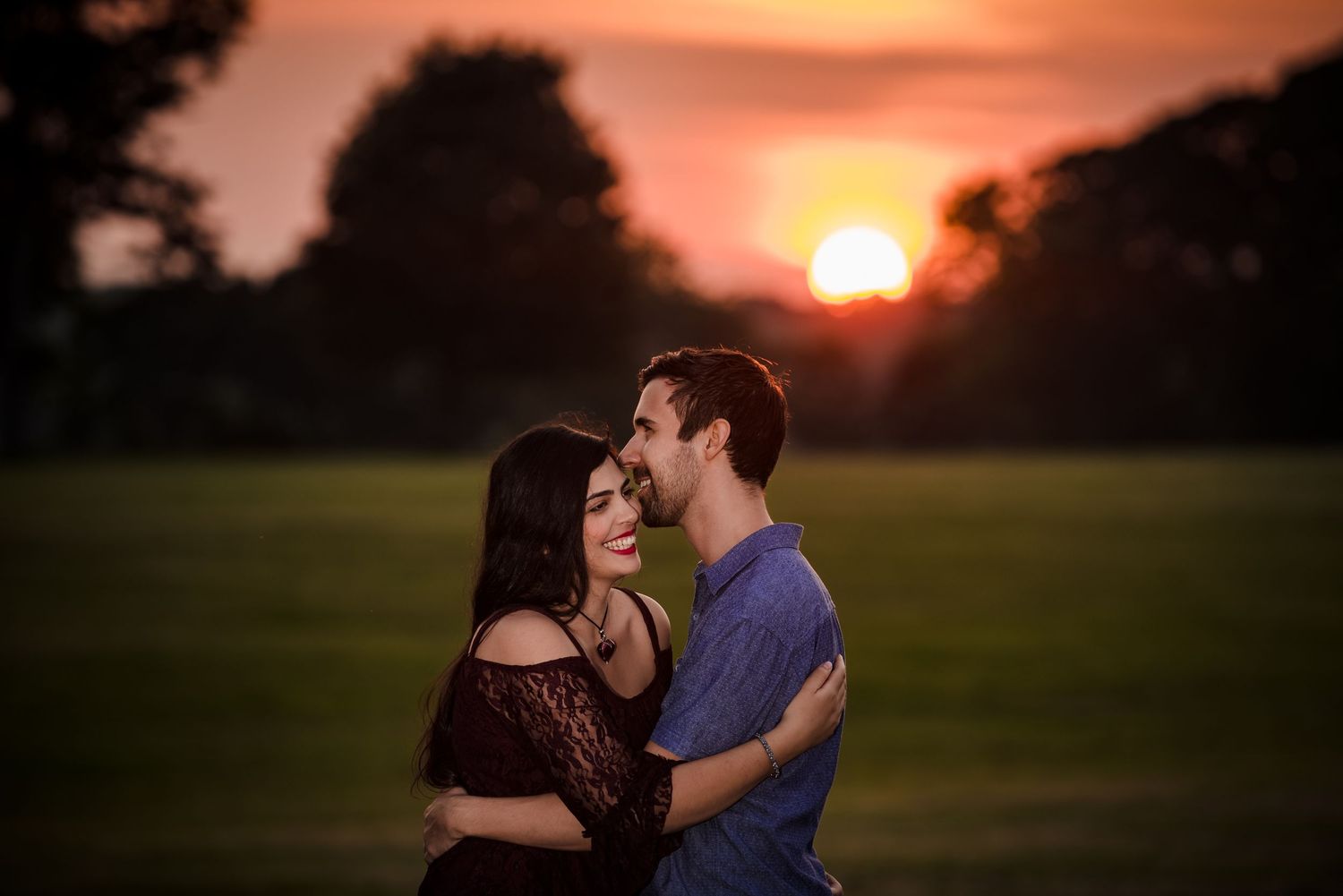 Sunset engagement session in an open field with dramatic orange sky. Taken by Rhode Island Photographer