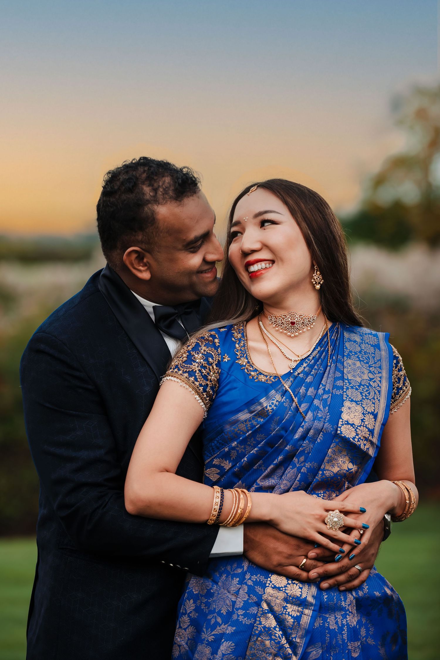 Romantic couple embracing outdoors at sunset in traditional Indian formal wear. Taken by Rhode island wedding photographer