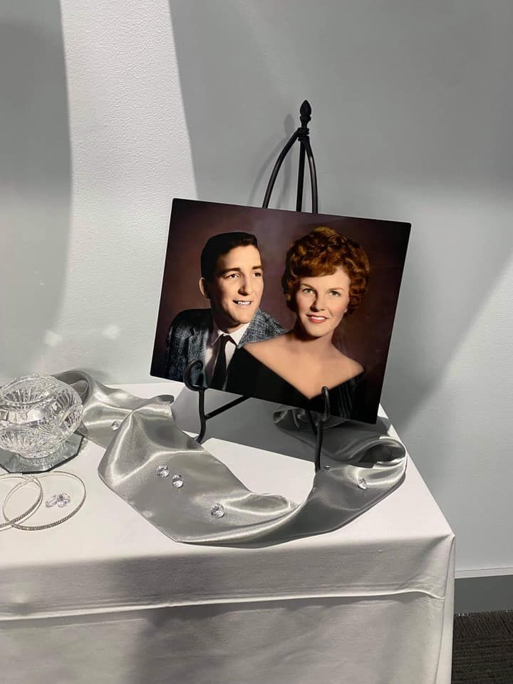 Wedding memorabilia display with photographs and decorative items on white surface. Photo Restoration