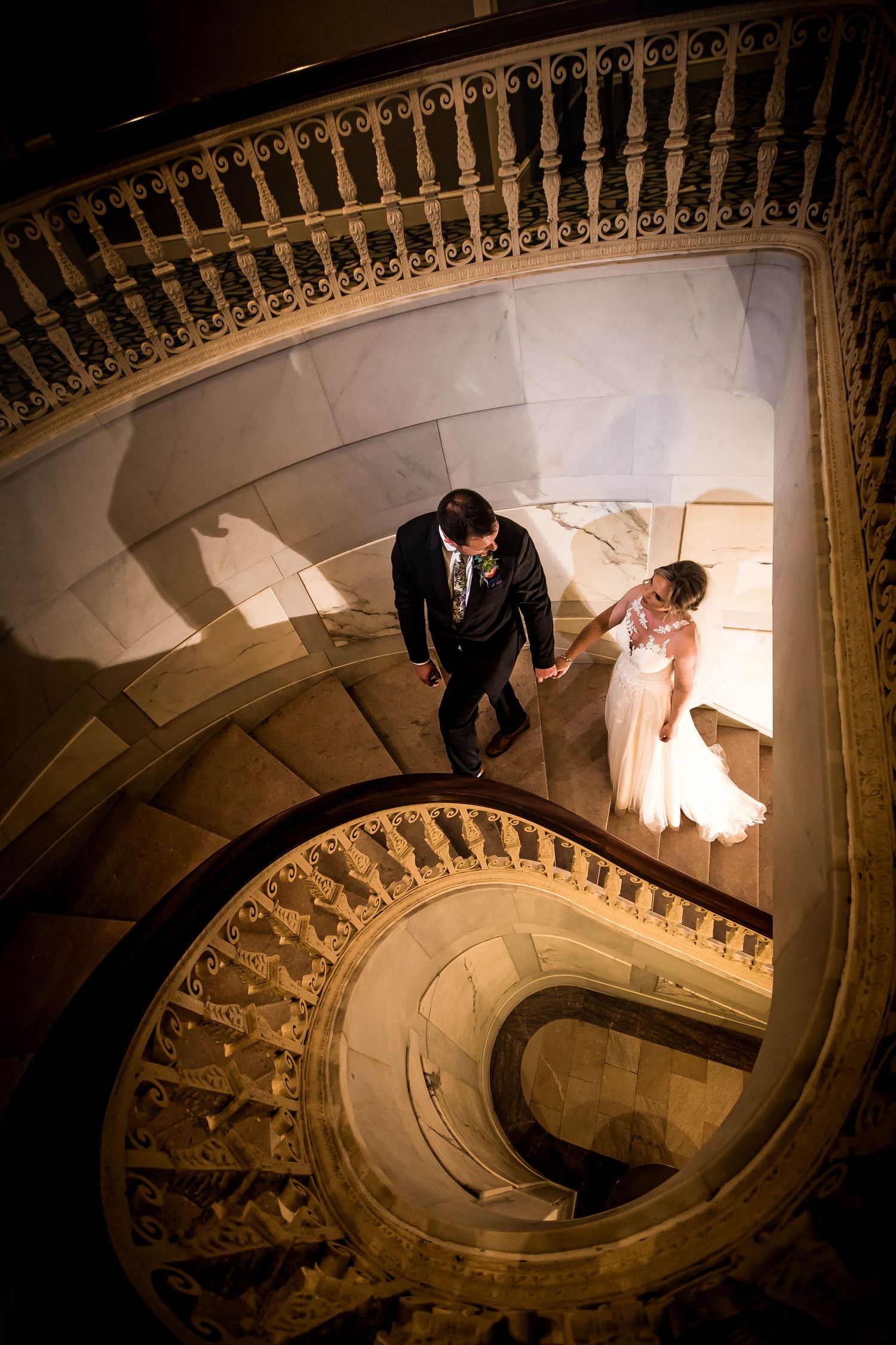 A spiral staircase photoshoot with dramatic shadows and elegant architecture. Taken by Rhode Wedding Island Photographer