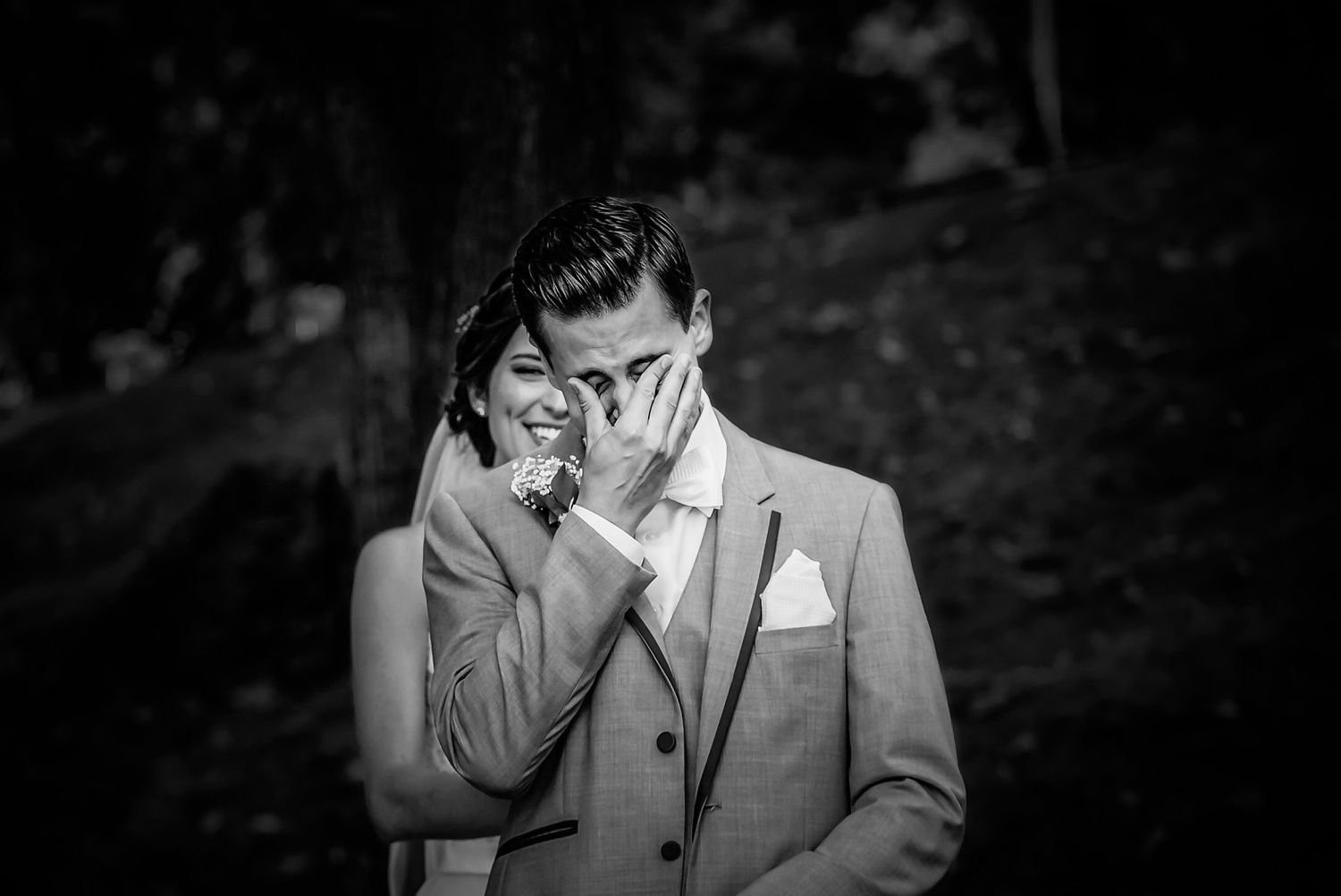 Black and white image shows emotional wedding moment with hands covering faces. Taken by Rhode island wedding photographer