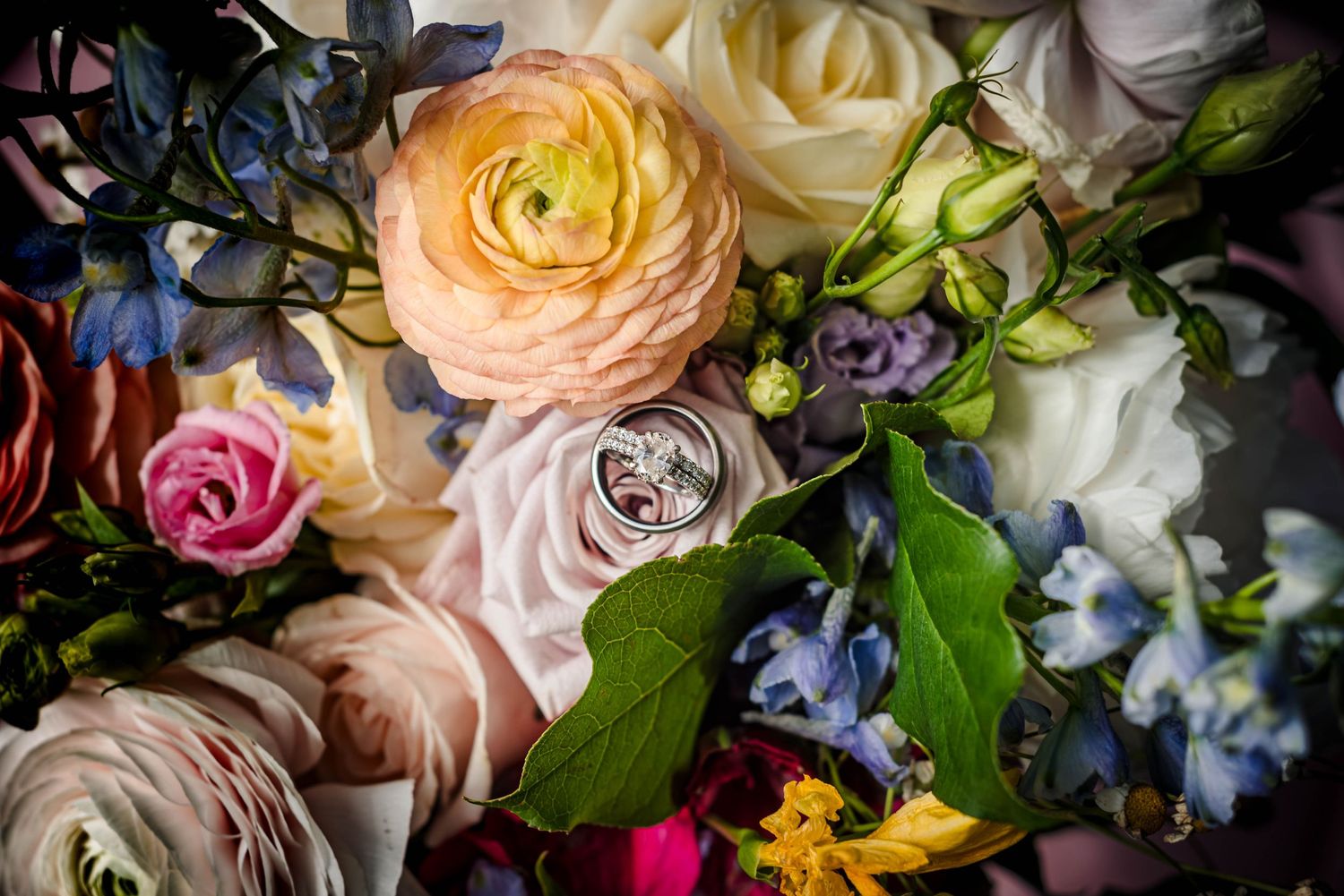 Colorful wedding bouquet arrangement with roses and mixed seasonal flowers.