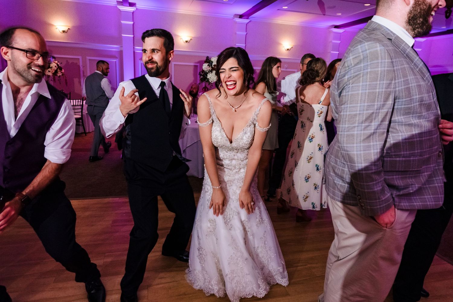 Wedding reception dance party with purple lighting and guests dancing. Taken by Rhode island wedding photographer