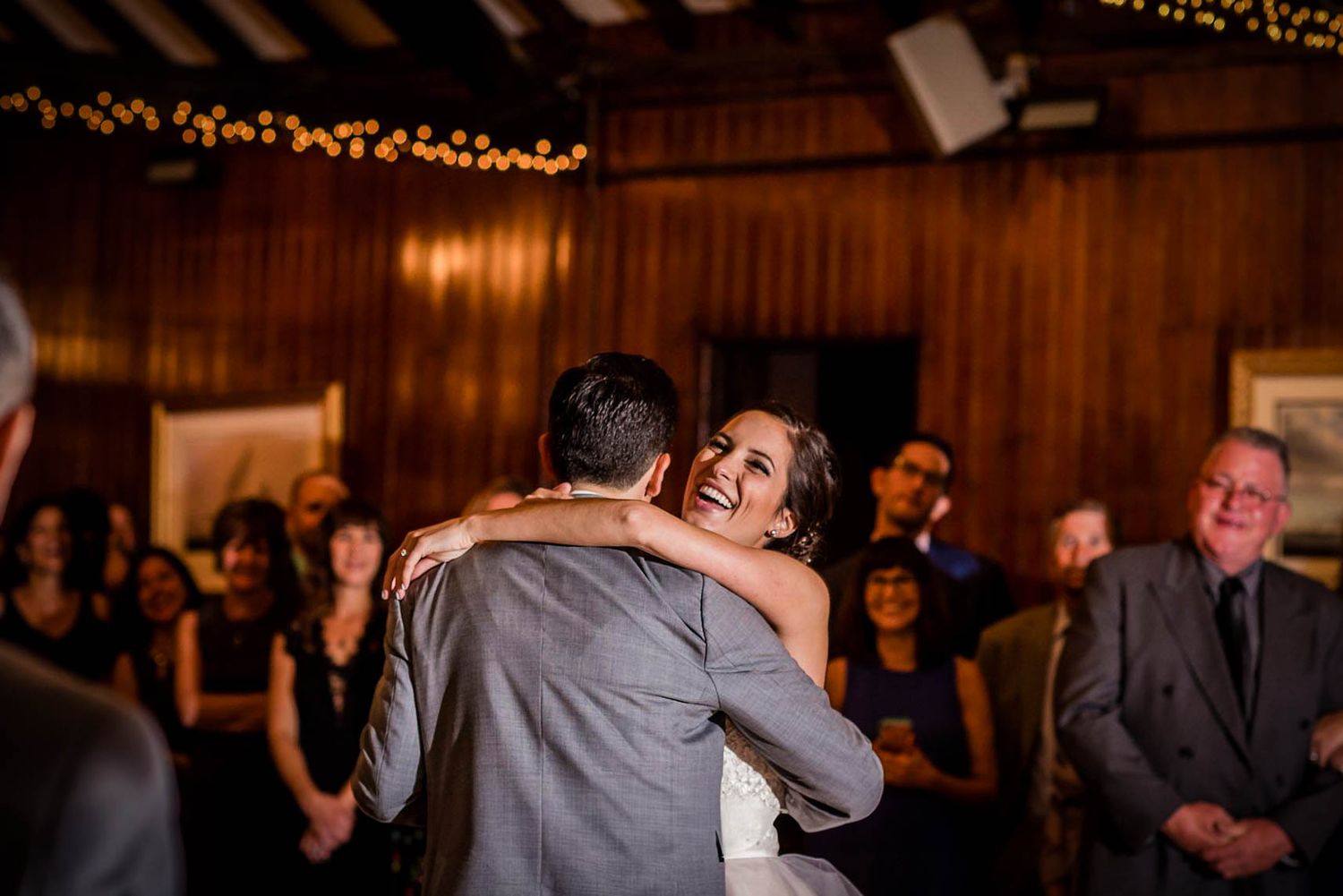 Wedding reception dance floor with warm lighting and wooden paneled walls. Taken by Rhode island wedding photographer