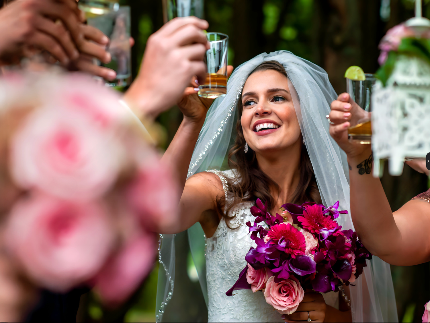 A celebratory toast moment with colorful floral bouquet and drinks. Taken by Rhode island wedding photographer