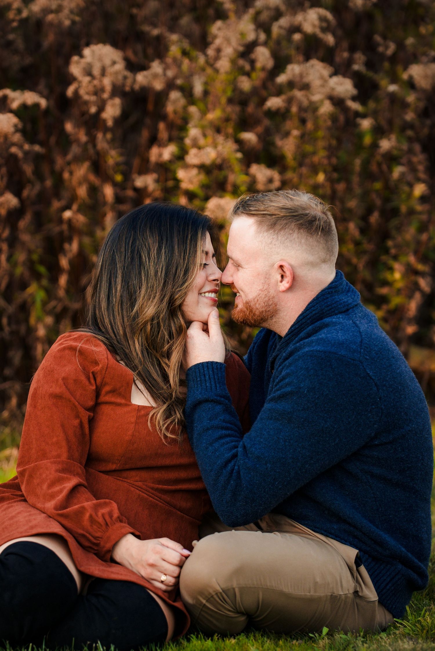 Intimate couple's portrait session among fall foliage with warm lighting. Rhode Island Engagement Taken by Rhode Islan