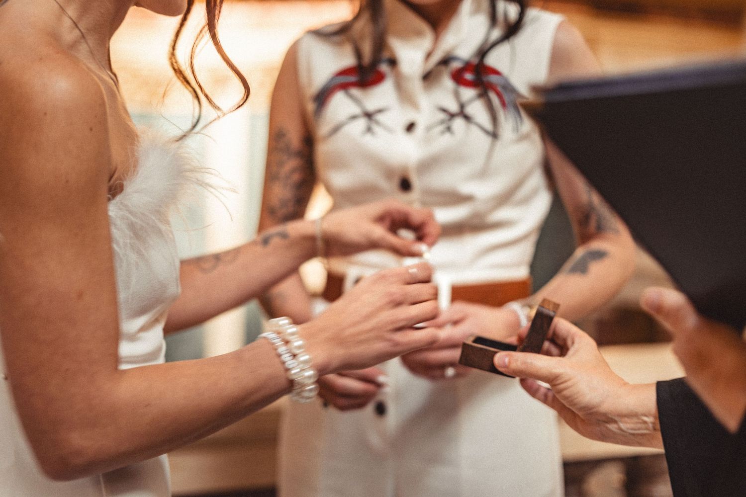 A close-up shot of hands exchanging wedding rings during a marriage ceremony.