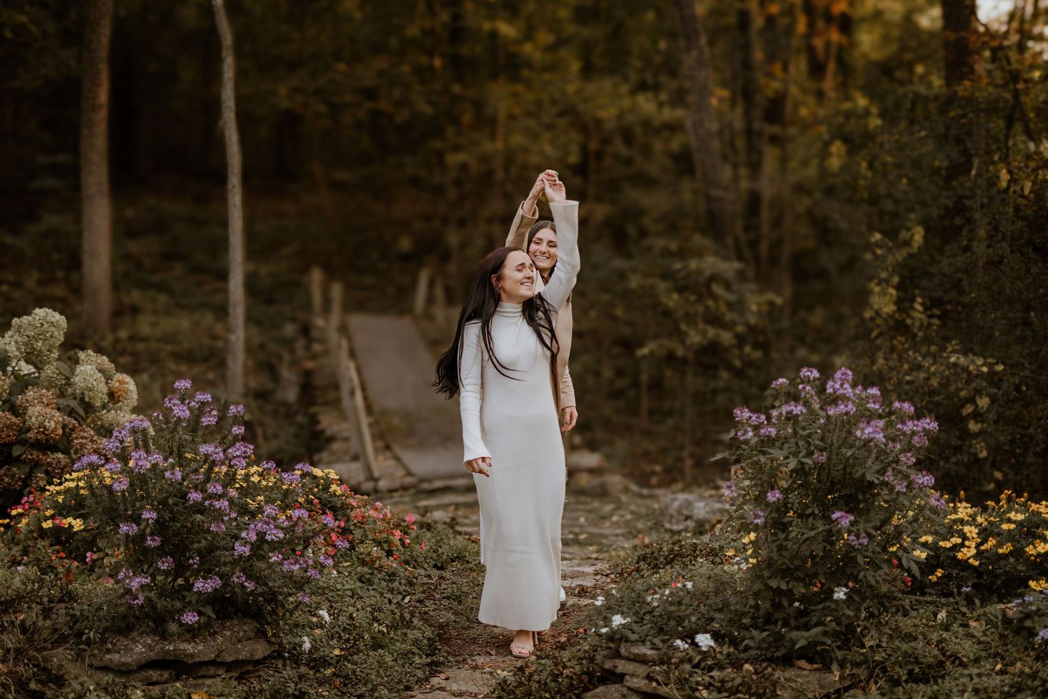 A romantic outdoor engagement session in a garden with purple flowers.