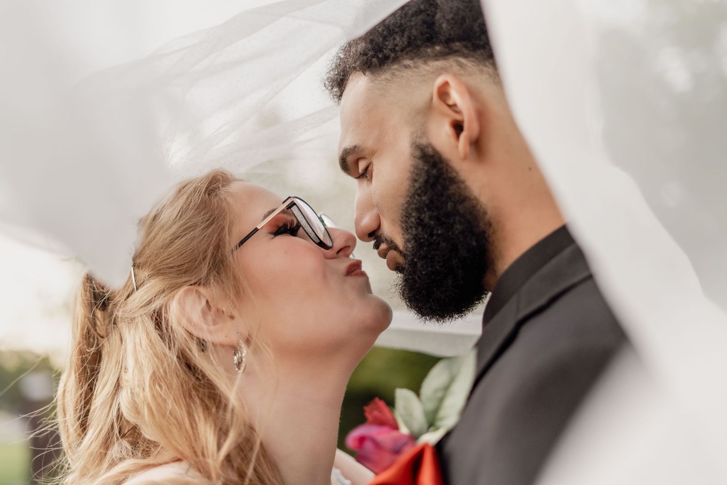 A couple shares an intimate kiss during their wedding ceremony, with soft lighting and romantic ambiance.