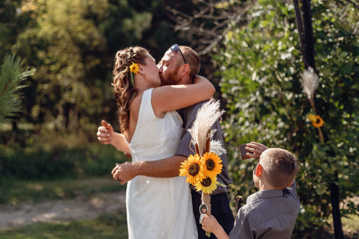 Wedding celebration with couples embracing outdoors among greenery.