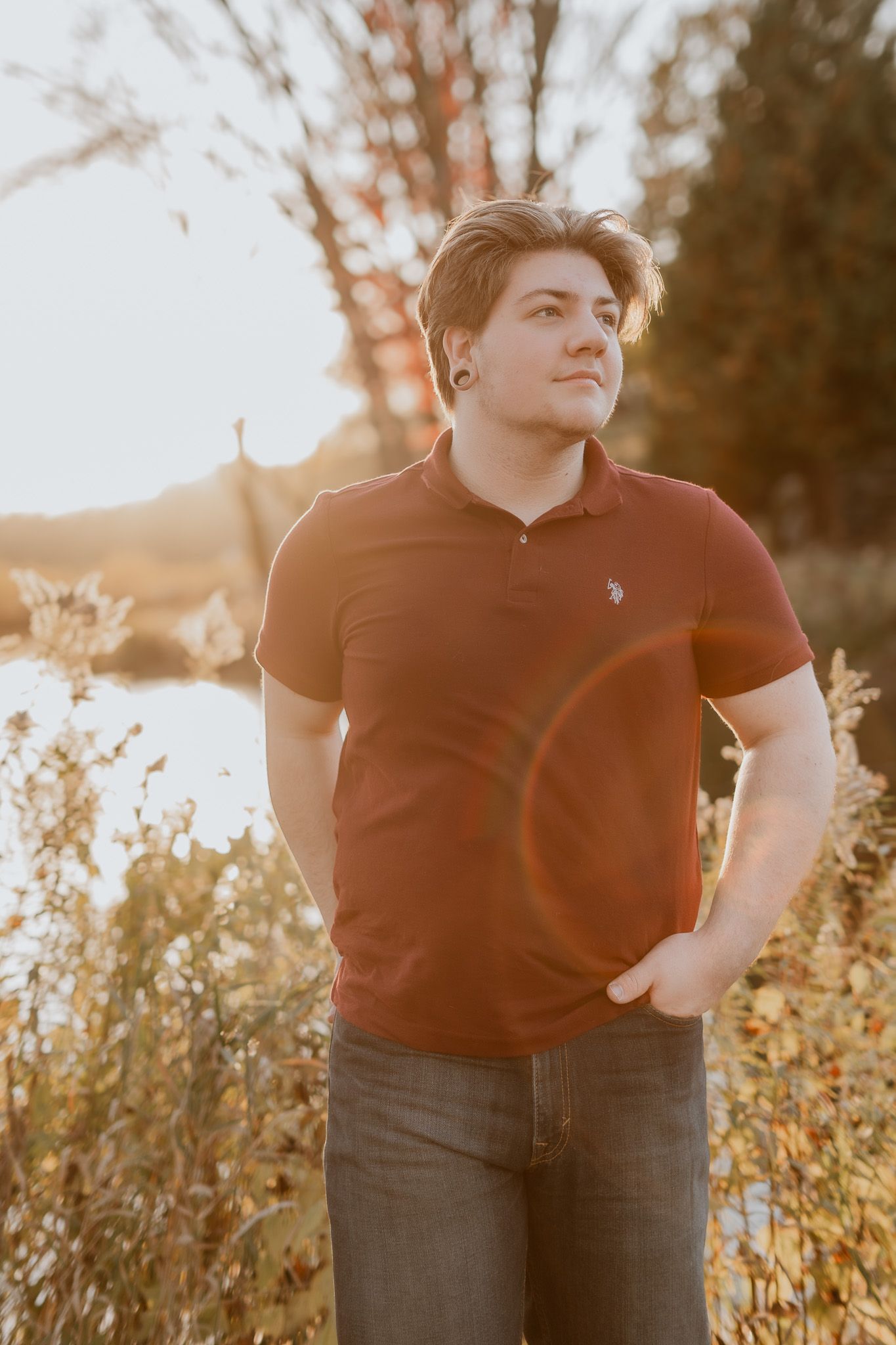 A casual outdoor portrait of someone in a red polo shirt during golden hour.