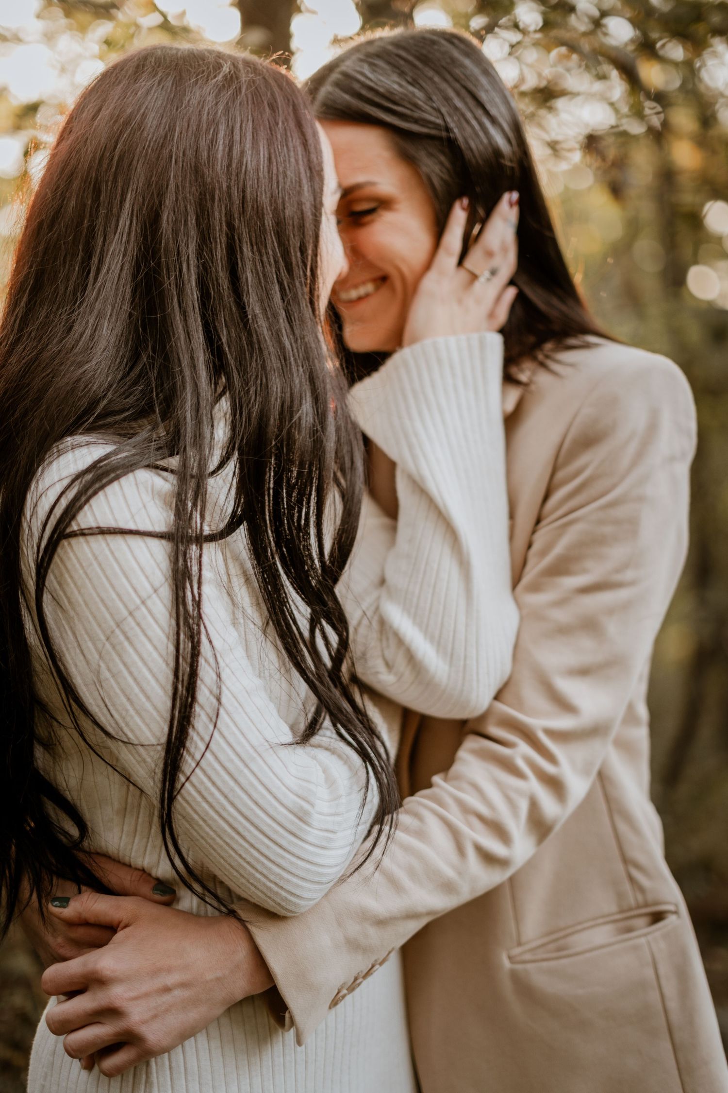 Intimate couple portraits in soft natural lighting among trees.