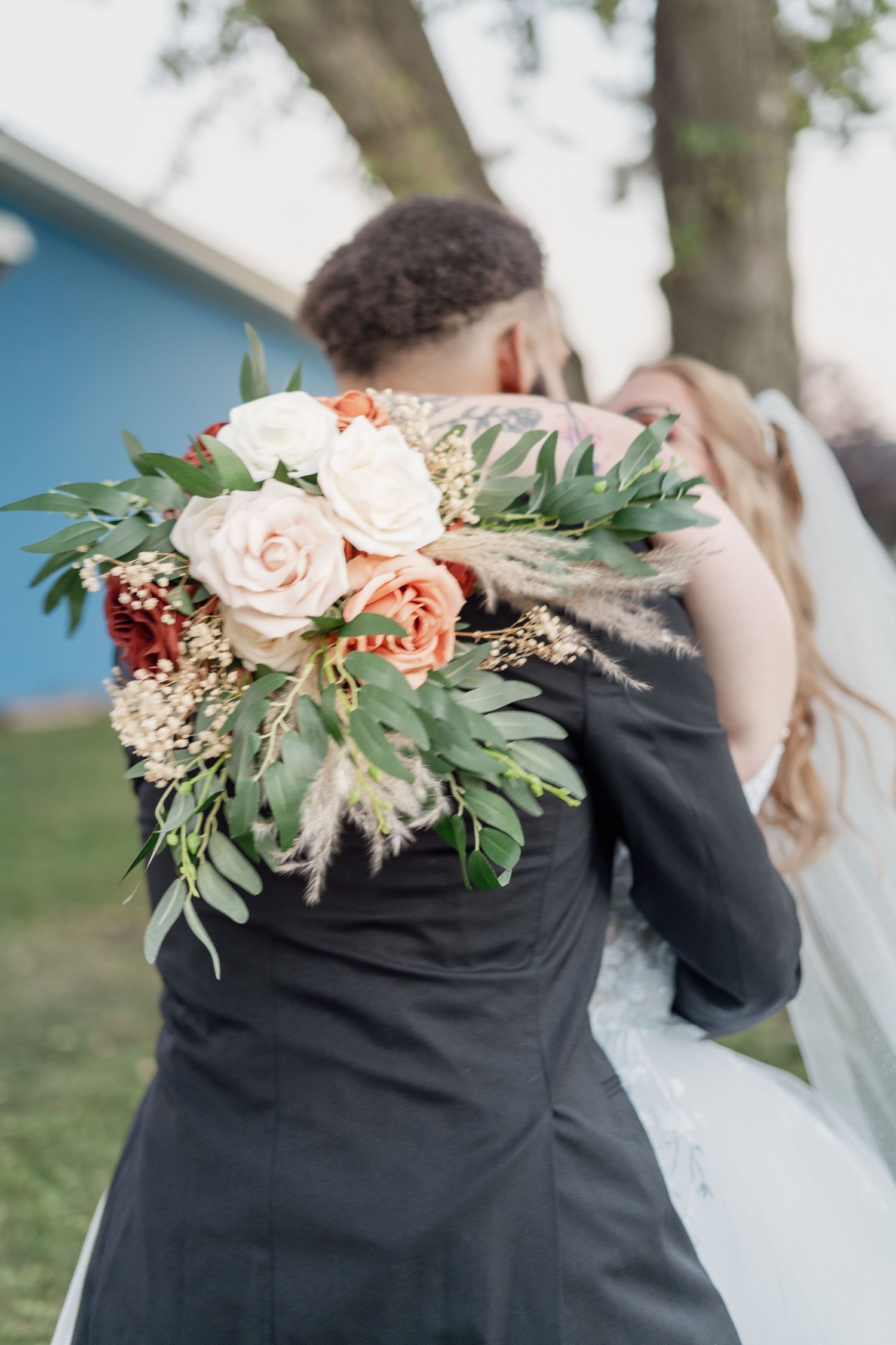 Beautiful floral arrangement with peach roses and eucalyptus leaves decorates a wedding scene.