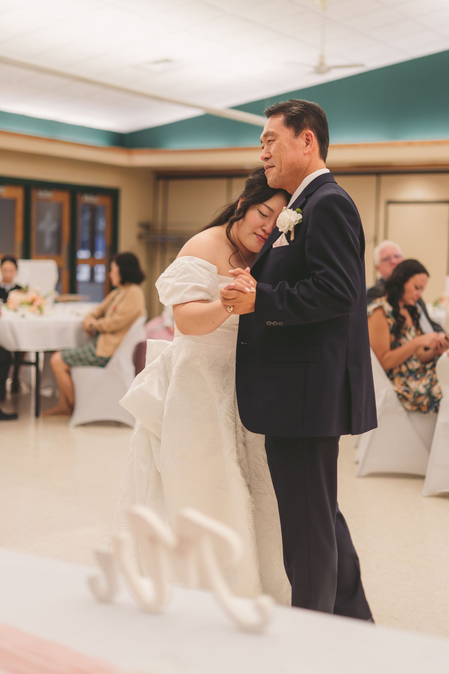 Bride and father share emotional first dance at wedding reception in elegant venue.