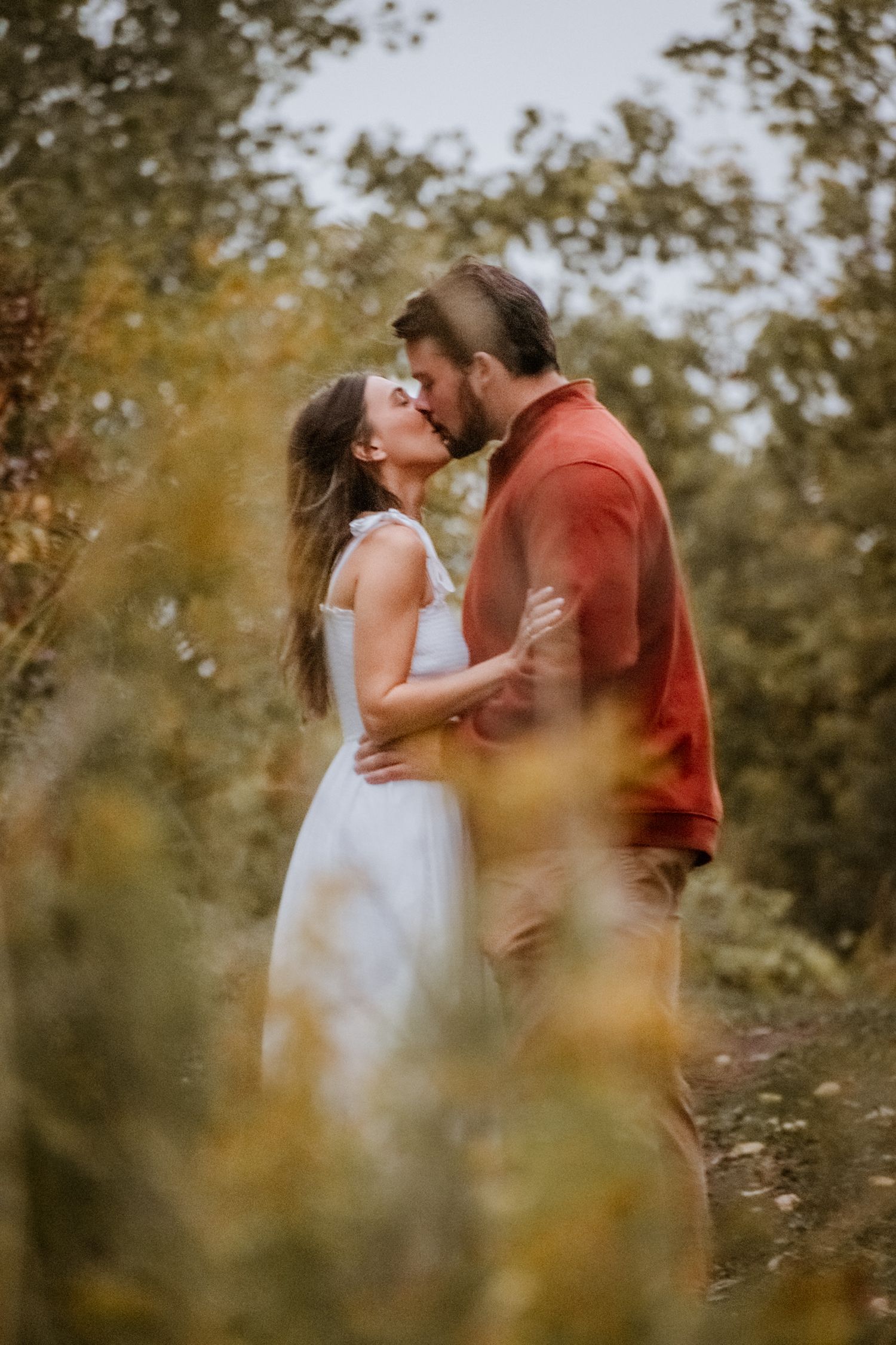 Intimate couple portraits through wildflowers during golden hour.