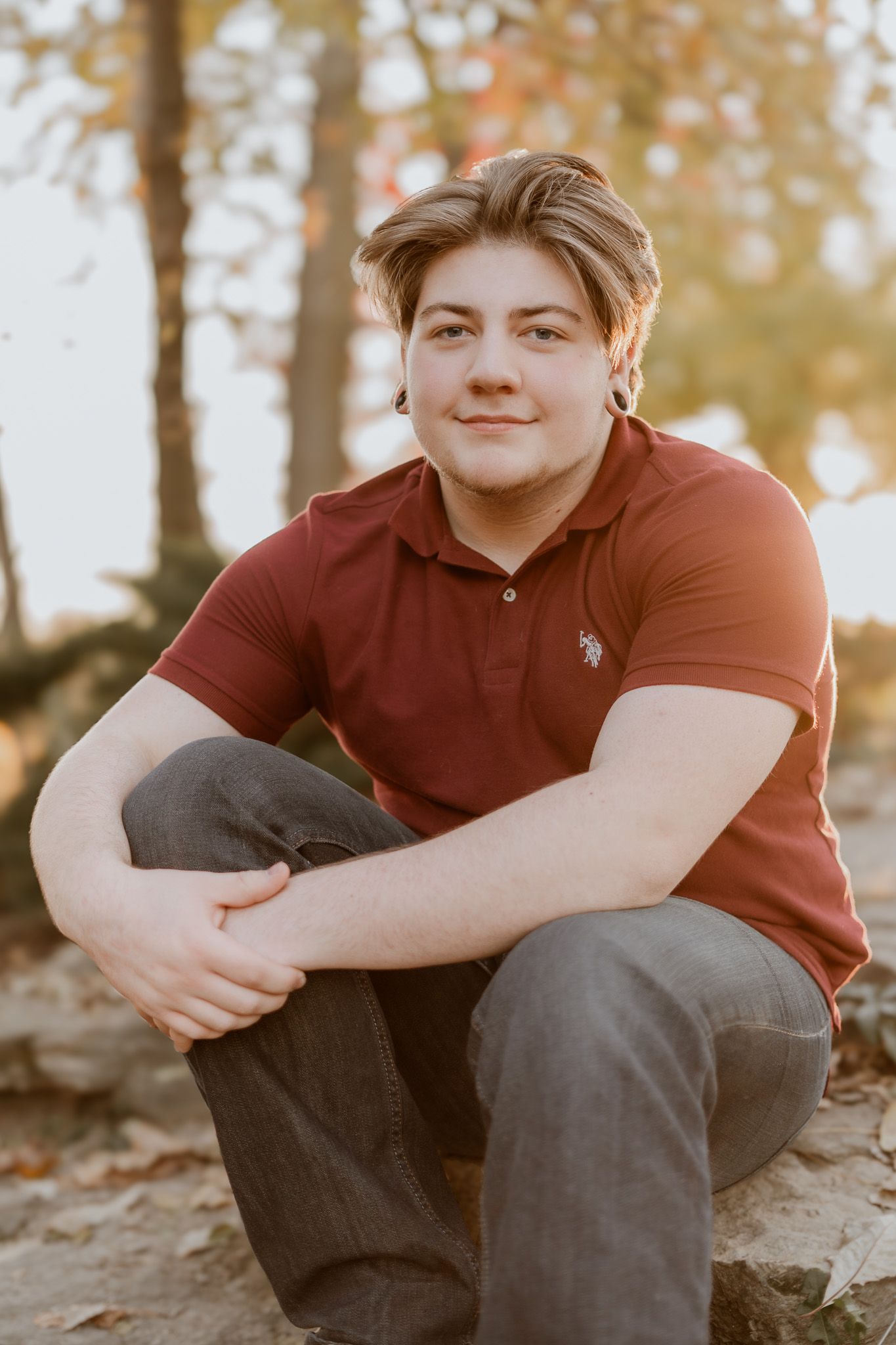 A casual portrait of someone in a red polo shirt sitting outdoors.