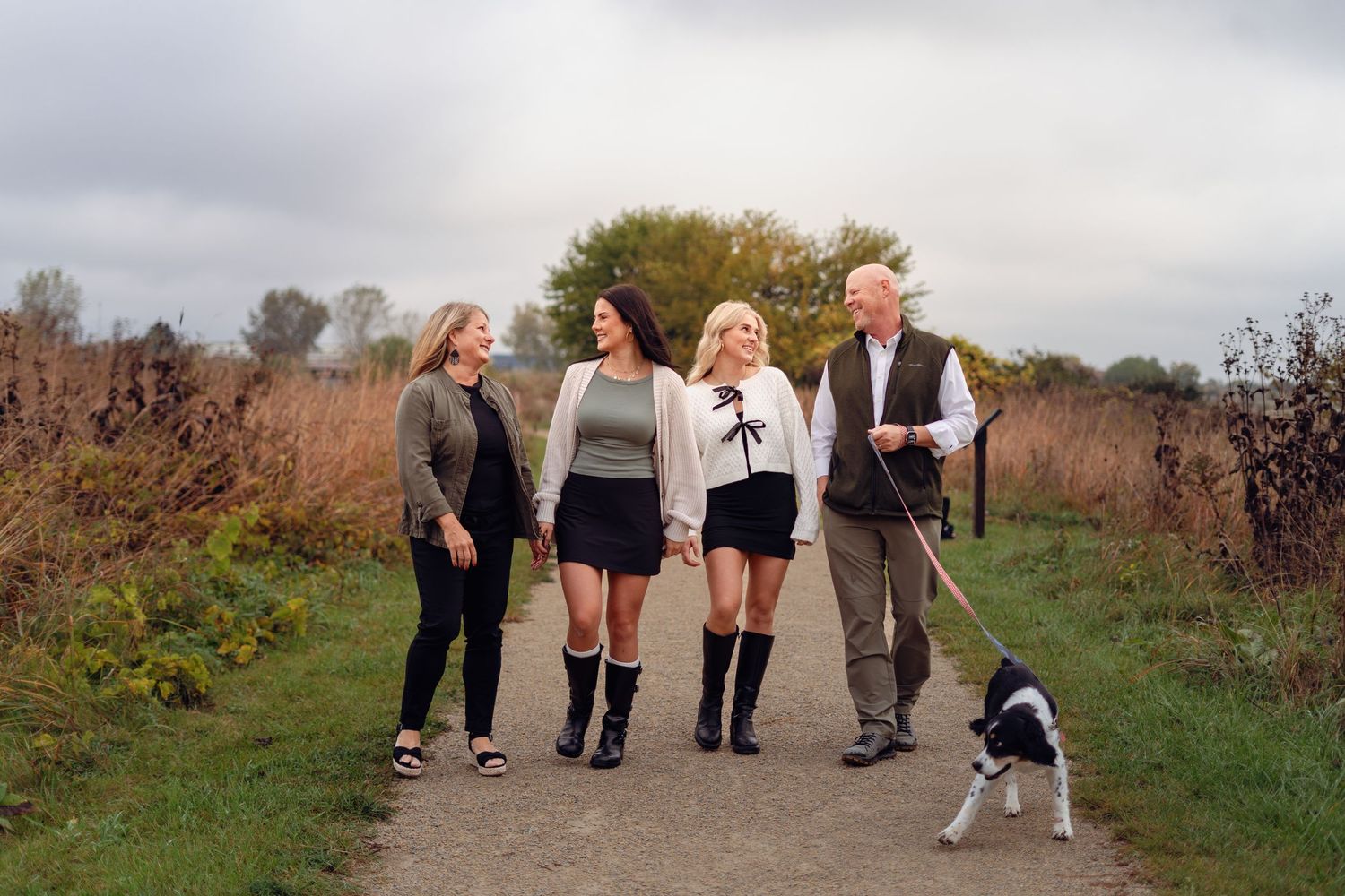 Group walking together on a path through autumn fields at sunset.