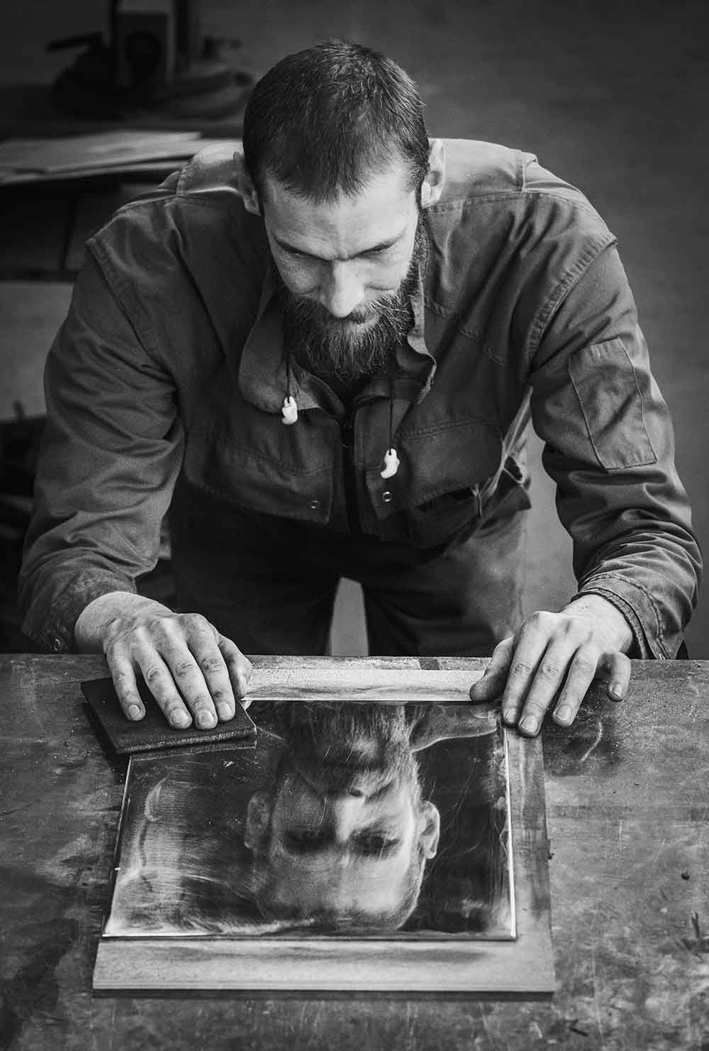 Intiem zwart-wit beeld dat concentratie, authenticiteit en de schoonheid van het creatieve proces toont, een moment waarin de tijd vertraagt