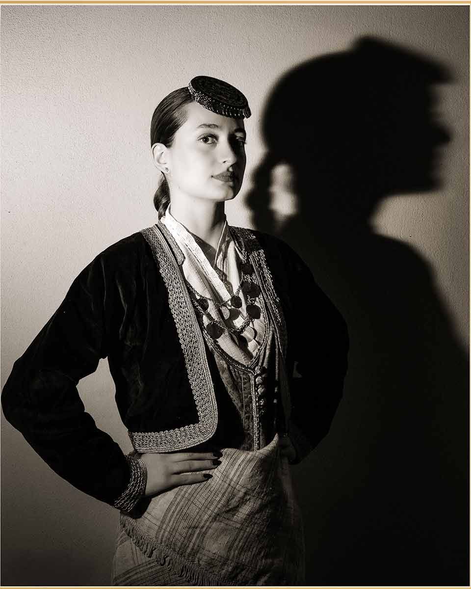 Black and white portrait of a woman wearing traditional attire, captured in profile with strong shadow play, highlighting heritage, characte