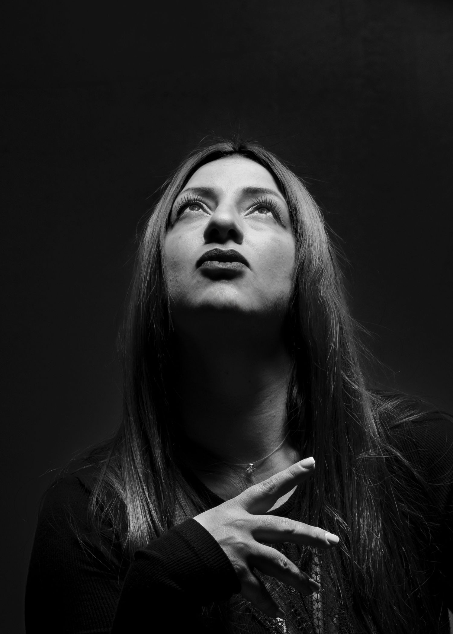 Studio modeportret van een vrouw tegen een gestructureerde achtergrond, met nadruk op zelfvertrouwen en verfijnde schoonheid.