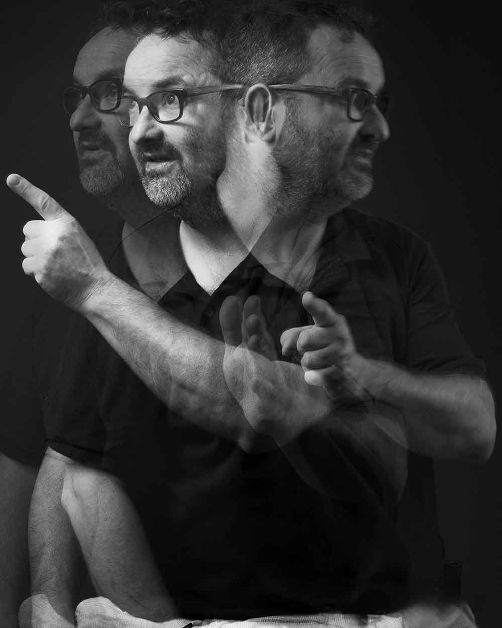 Artistiek zwart-wit studioportret van een man, gelaagd om beweging, karakter en innerlijke dialoog uit te drukken.
