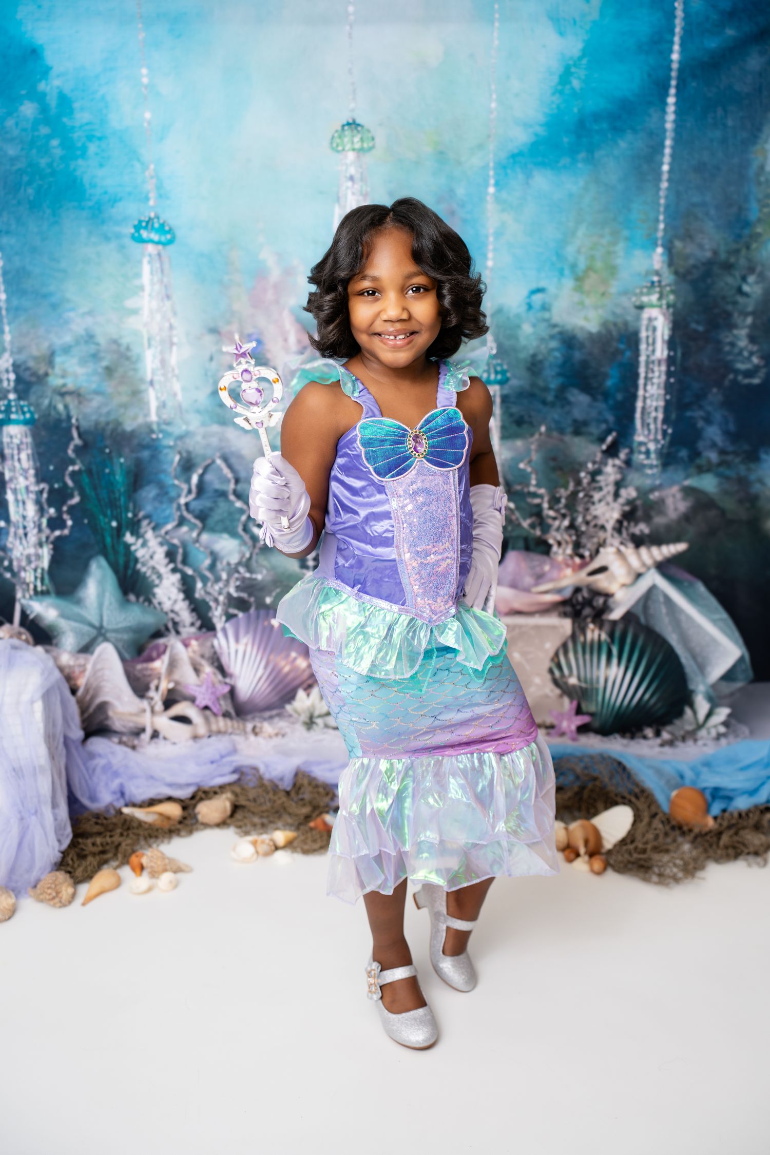 Metro Detroit children photographer photographing a toddler in a purple and silver party dress posing