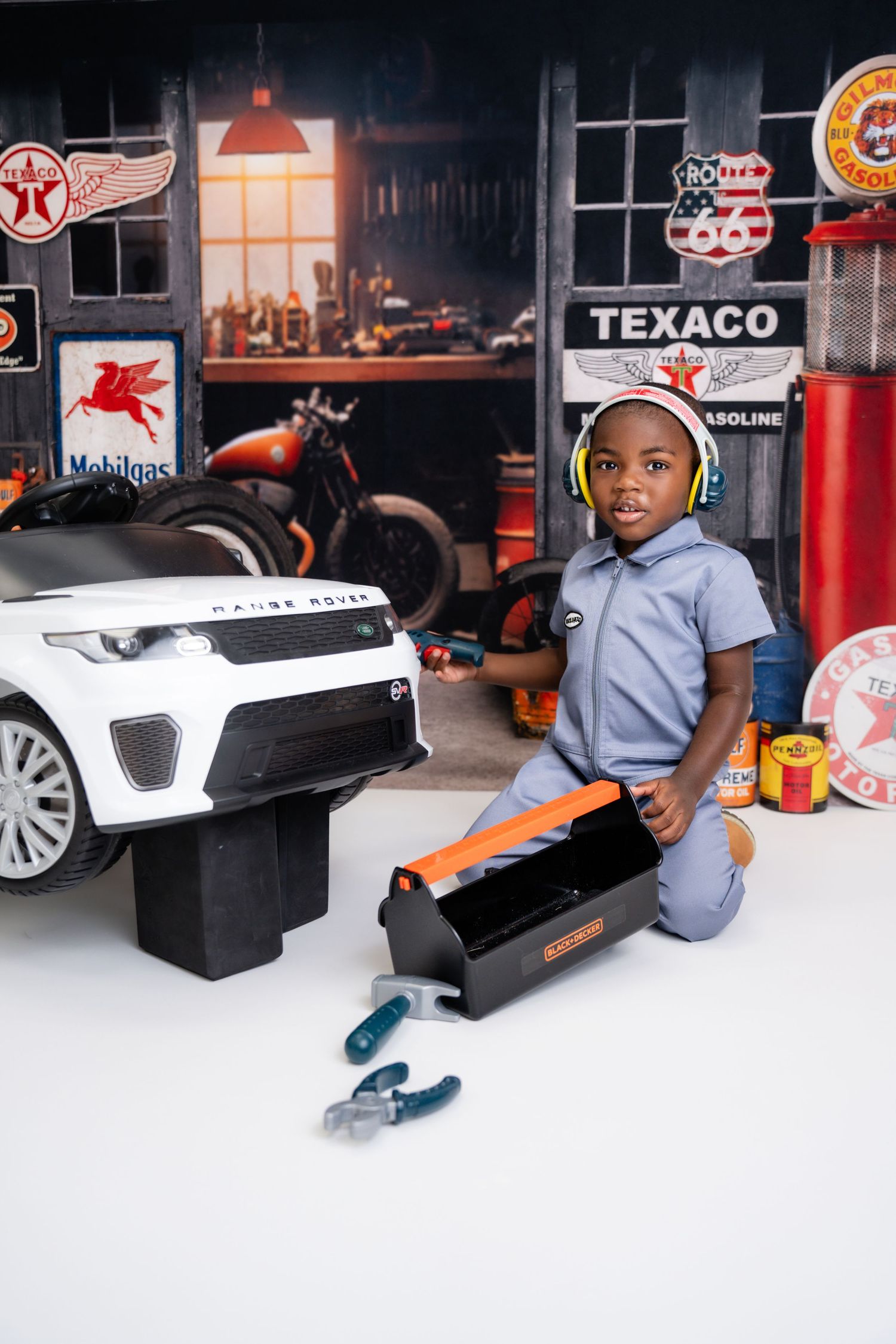 Metro Detroit children photographer Vintage auto shop themed photo setup with Texaco signs and toy car accessories.