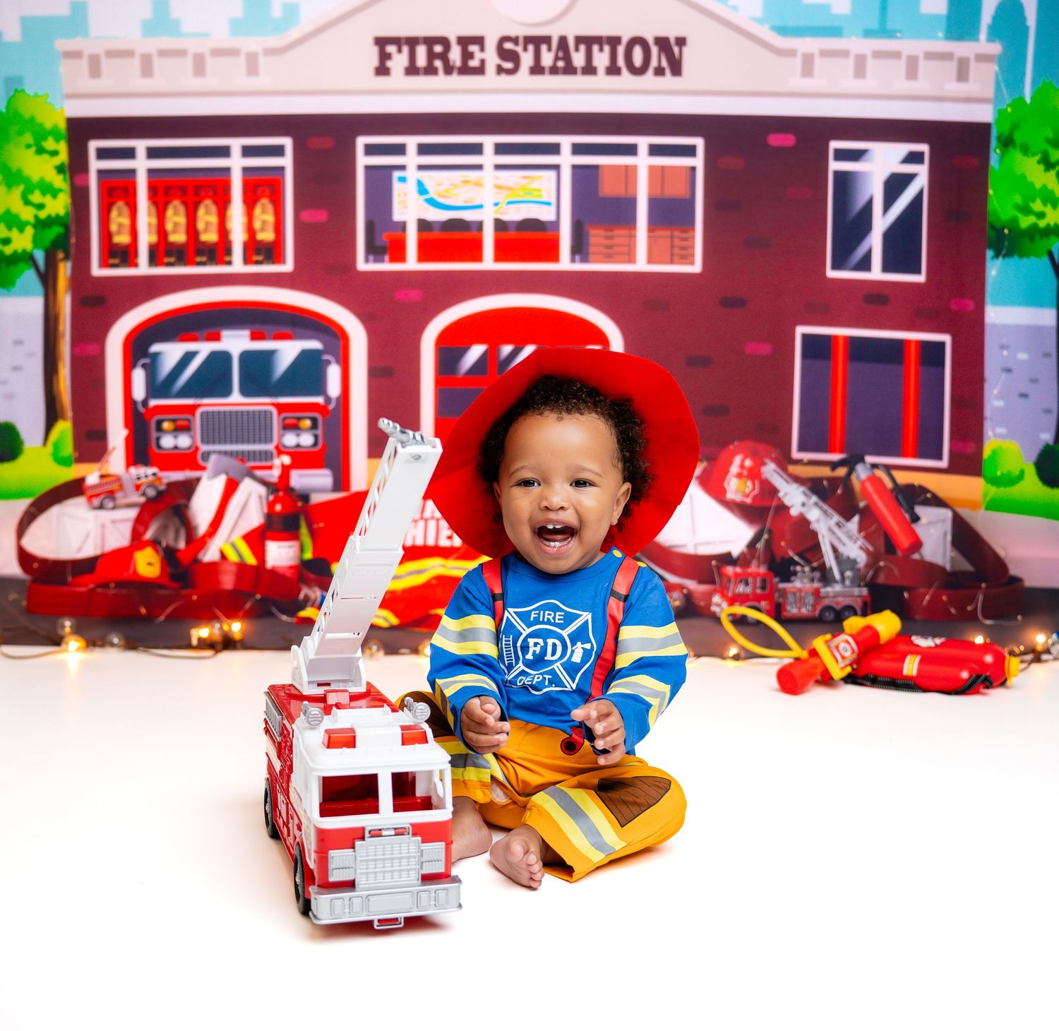 Metro Detroit children photographer photographing a playful toddler in studio with Fire station themed children's photo setup