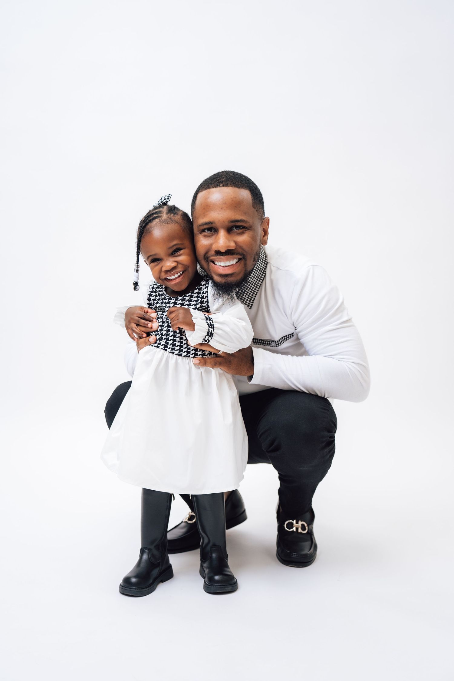 Metro Detroit family photographer capturing a Sweet studio portrait in black and white outfits against clean white background.