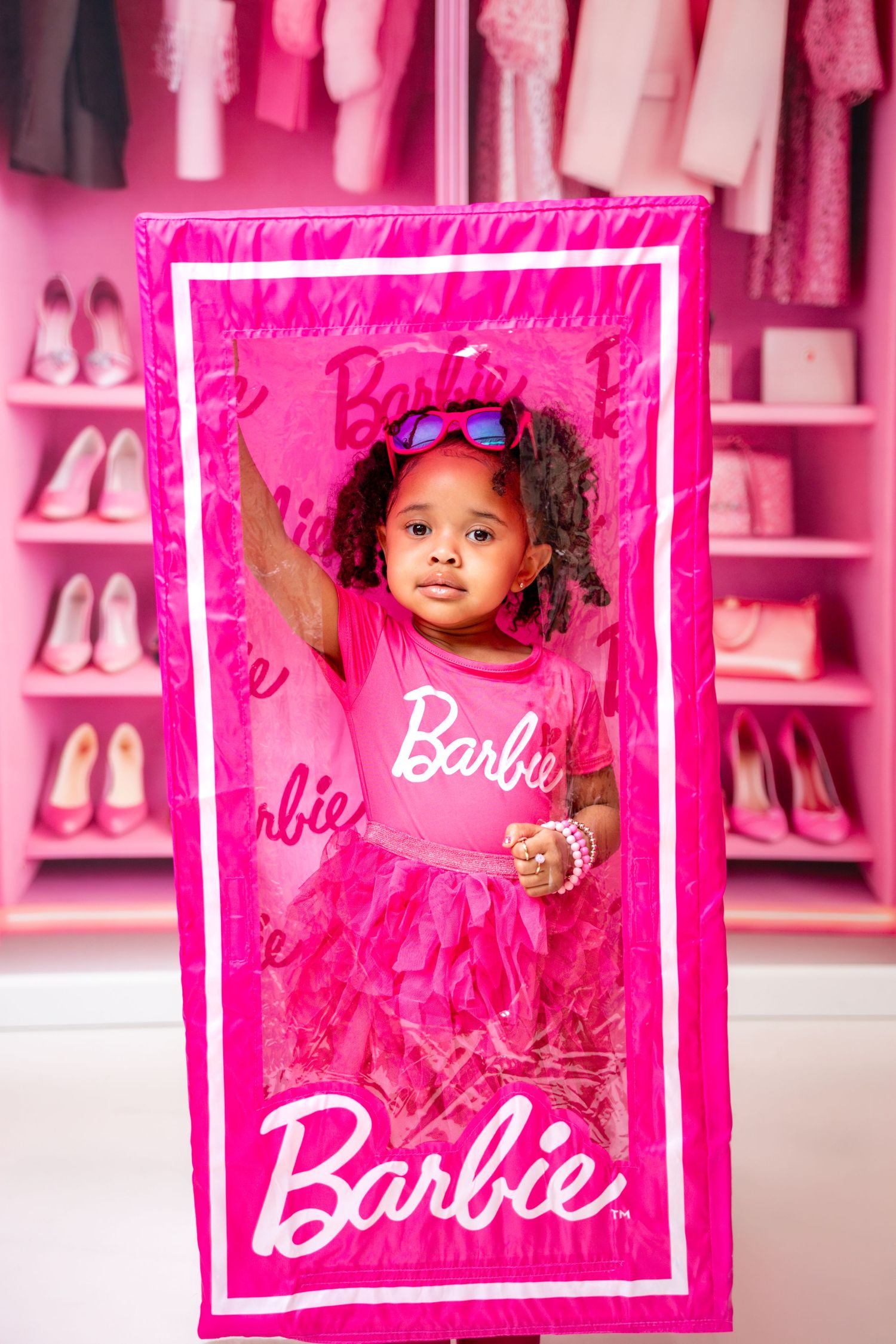 Metro Detroit children photographer photographing a playful  in studio Pink Barbie-themed photo setup with closet