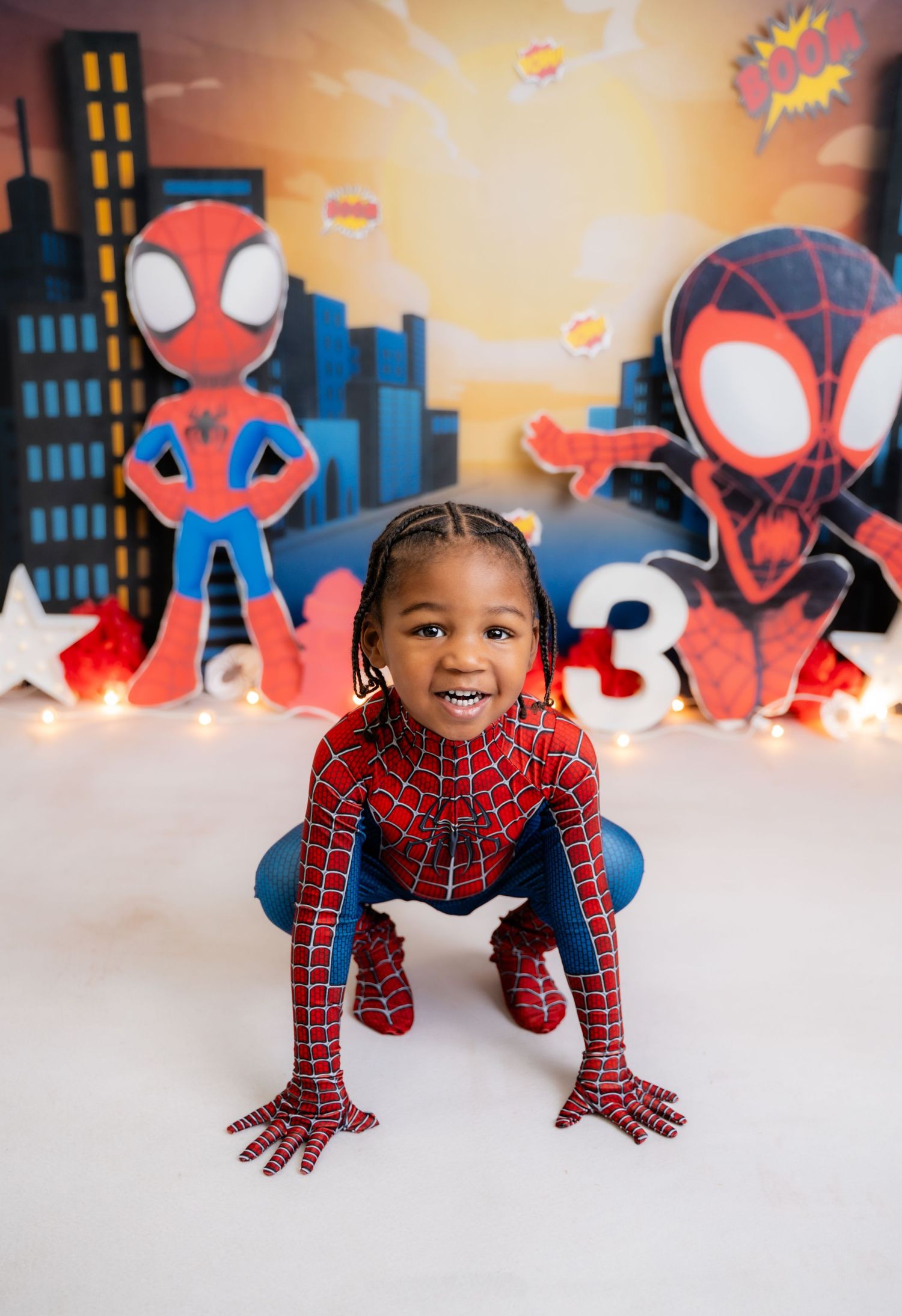 Metro Detroit children photographer Spider-Man themed photo session with city skyline backdrop and superhero decorations.