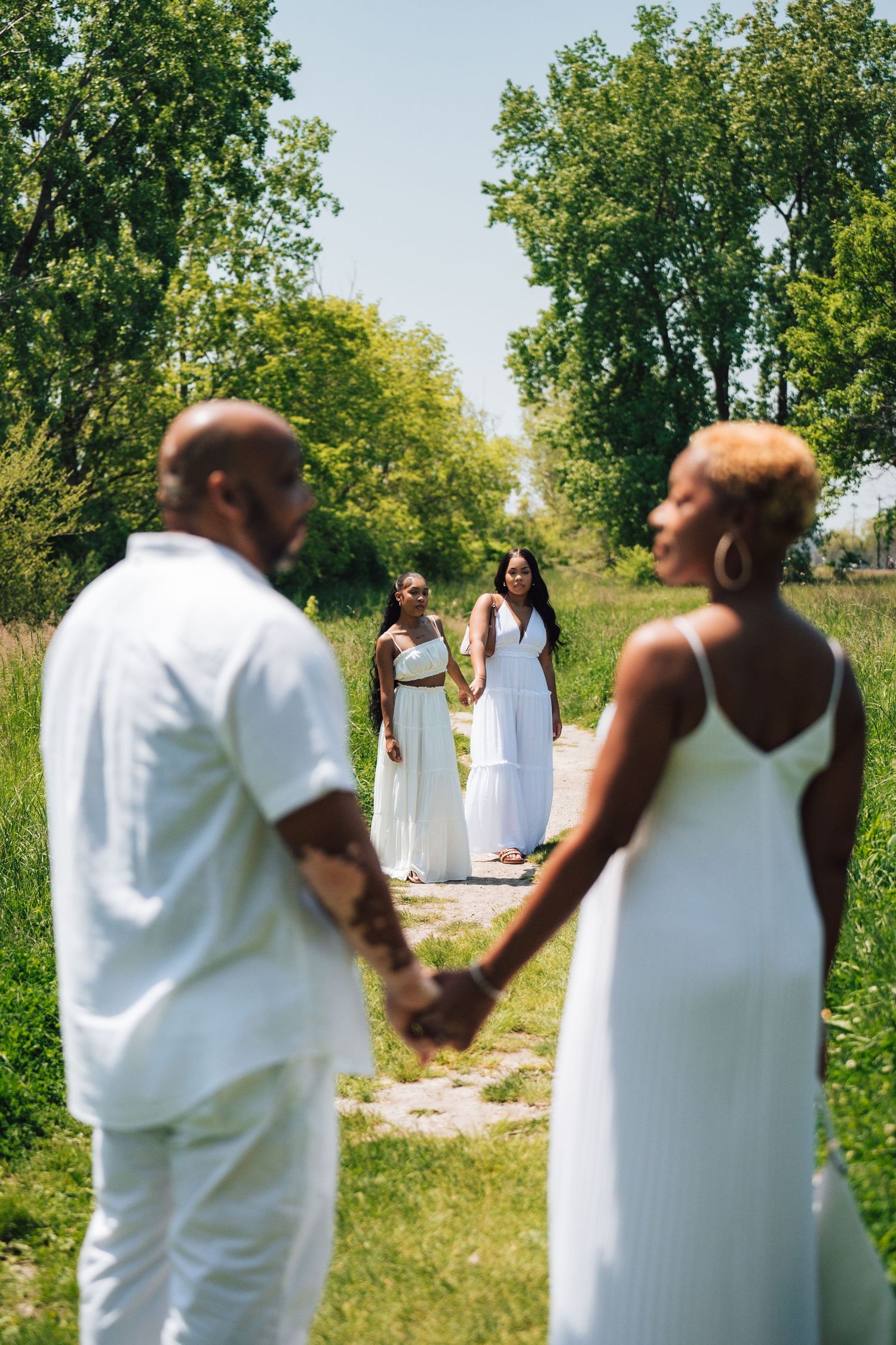 Metro Detroit family photographer capturing a family in white attire poses for romantic outdoor photoshoot