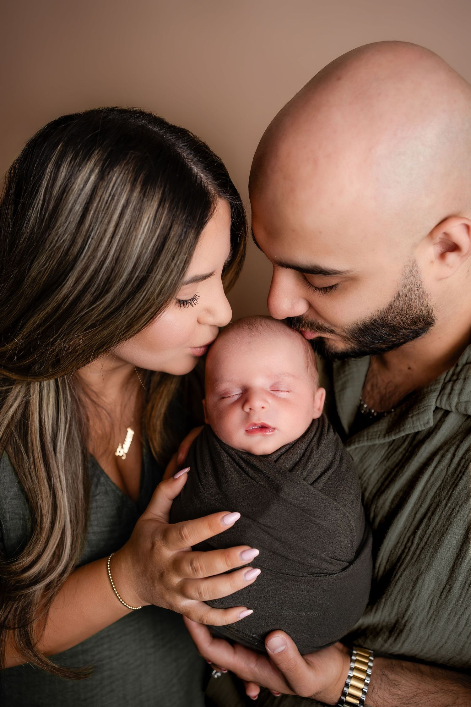 Metro Detroit newborn photographer capturing a peaceful newborn with parents portrait in studio