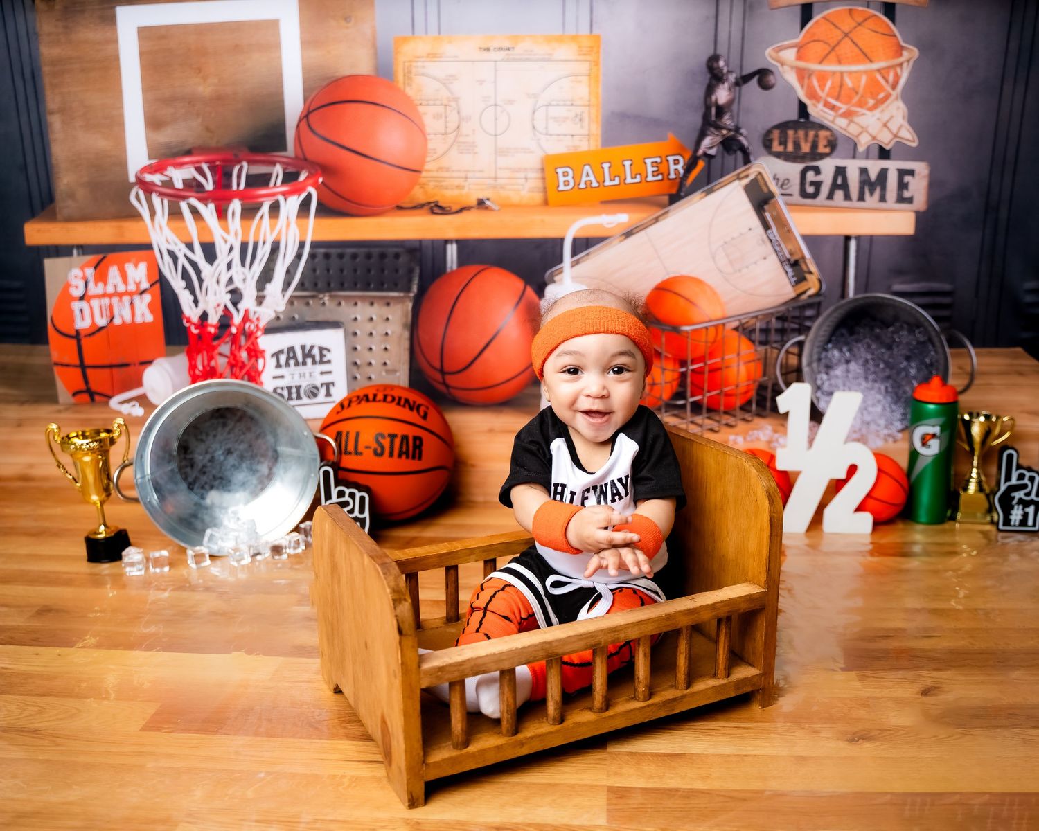 Metro Detroit children photographer Basketball-themed photoshoot with orange decor and wooden bench.