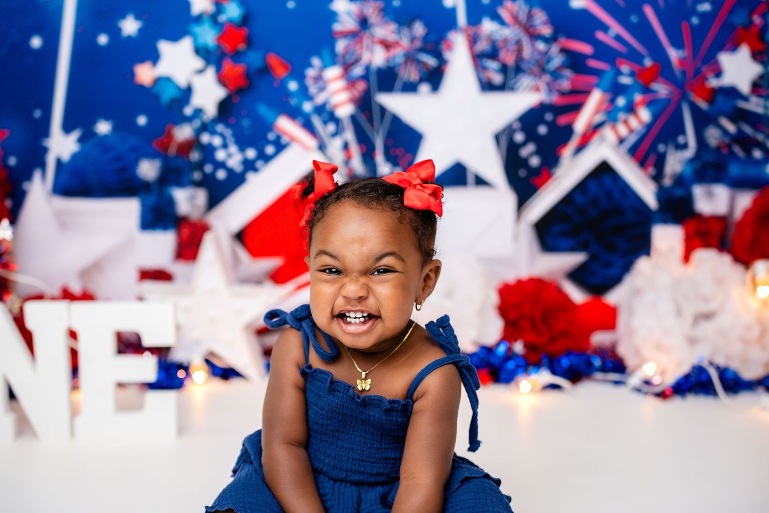 Metro Detroit children photographer Festive American-themed backdrop with fireworks, stars, and patriotic decorations.