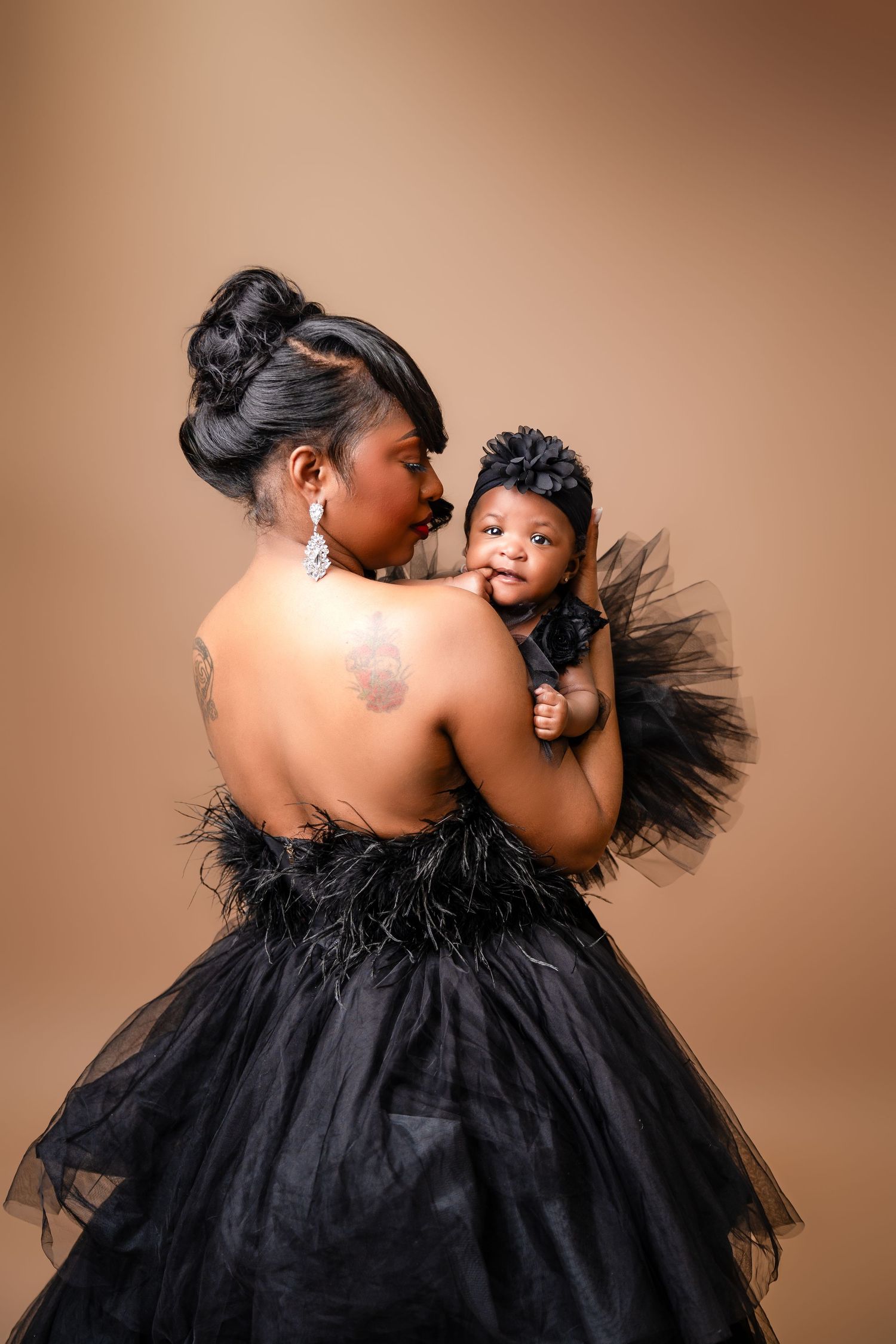 Metro Detroit family photographer capturing Intimate portrait series featuring black tulle dress against warm brown studio backdrop.
