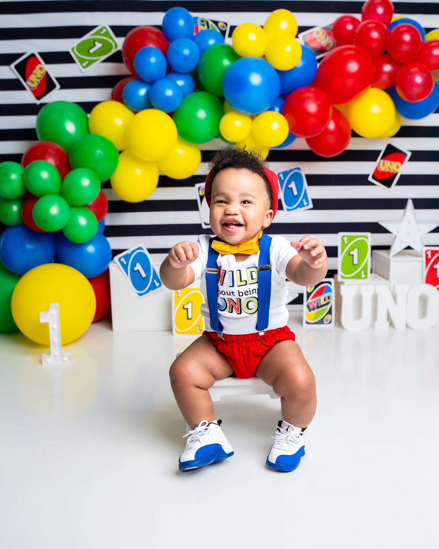 Metro Detroit children photographer photographing a playful toddler in studio UNO themed photo setup