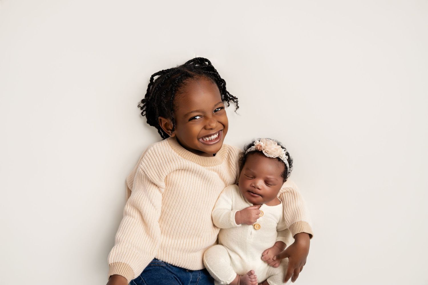 Metro Detroit newborn photographer capturing a peaceful newborn  with big siblings portrait in studio