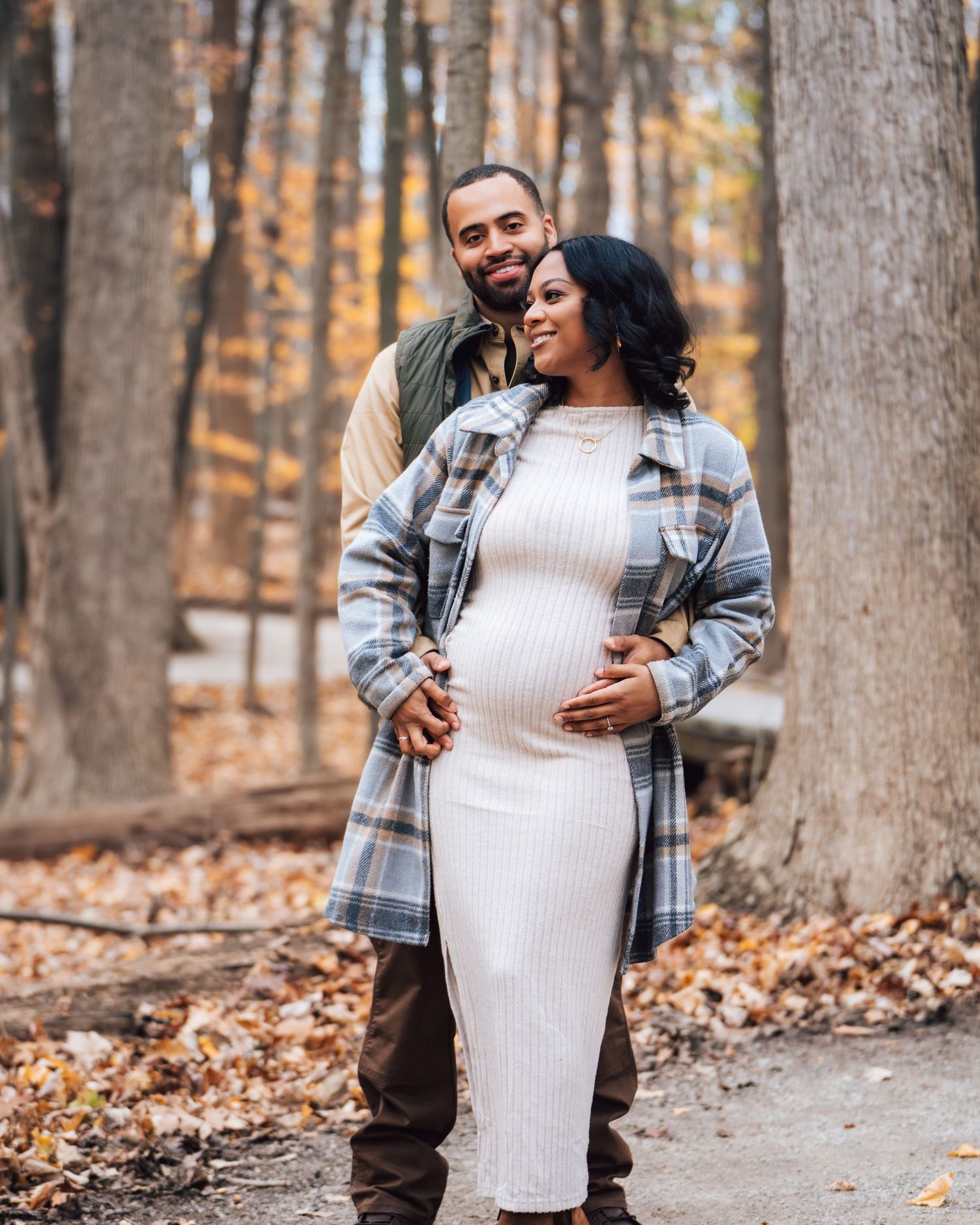 Metro Detroit maternity photographer capturing an expecting mother Outdoor autumn maternity photos with couple among fall foliage.