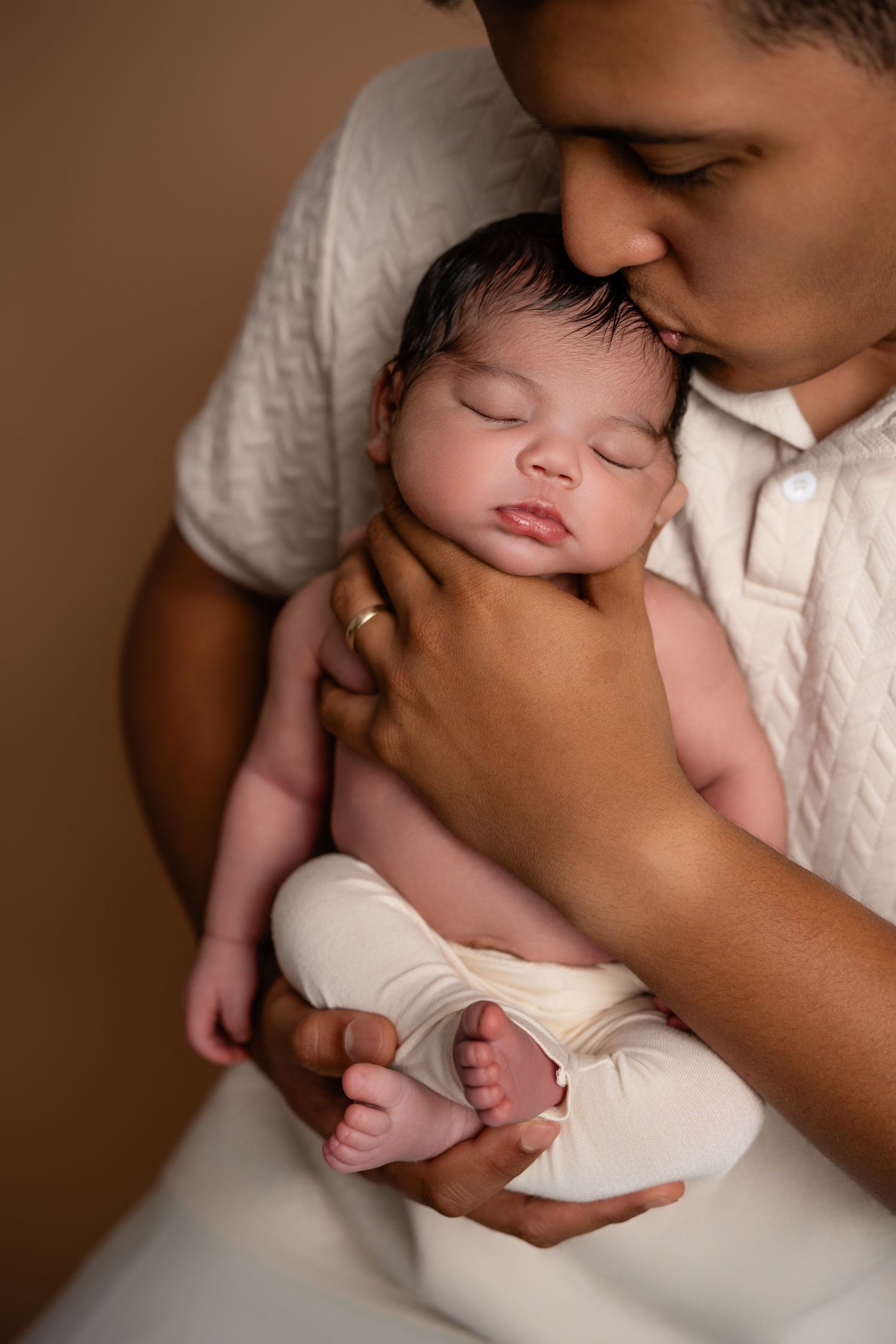 Metro Detroit newborn photographer capturing a peaceful newborn portrait in studio with dad,