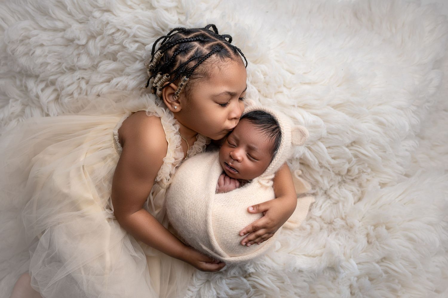 Metro Detroit newborn photographer capturing a peaceful newborn portrait in studio with sister