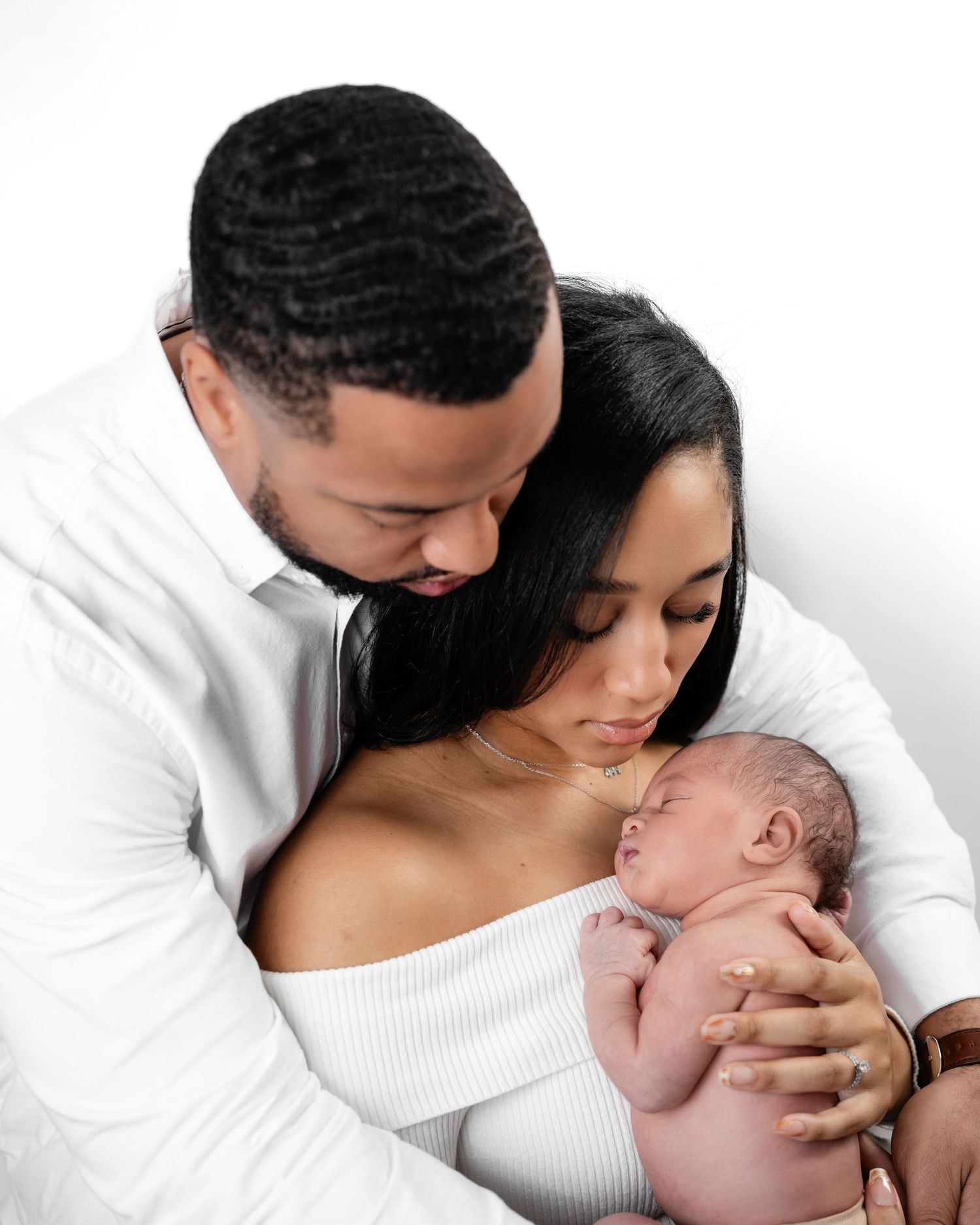 Metro Detroit newborn photographer capturing a peaceful newborn with parents portrait in studio