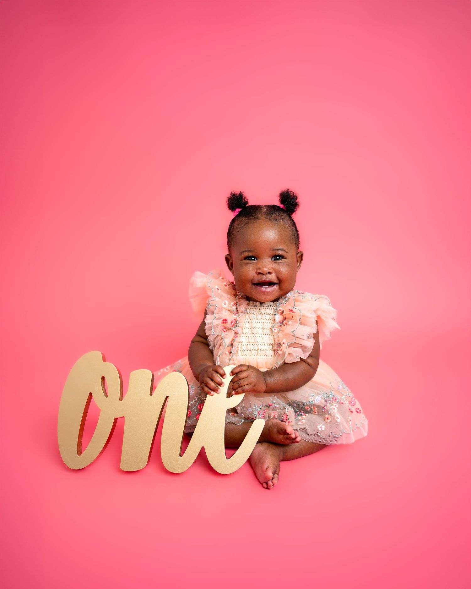 Metro Detroit children photographer photographing a playful toddler in studio Pink backdrop birthday photo setup