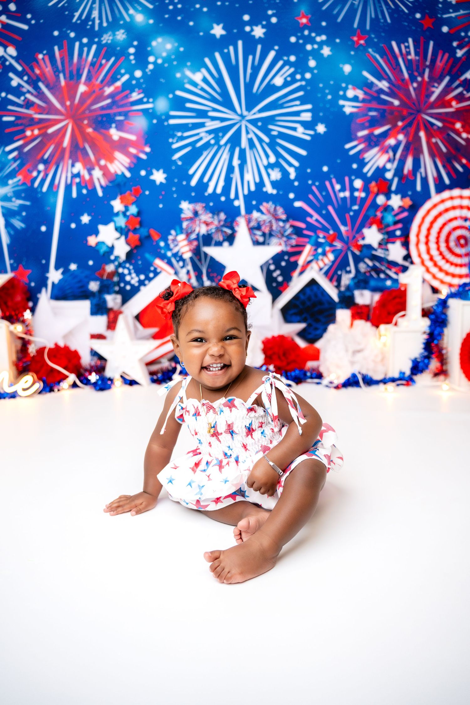 Metro Detroit children photographer Patriotic photo backdrop featuring red, white, and blue fireworks against a starry sky.