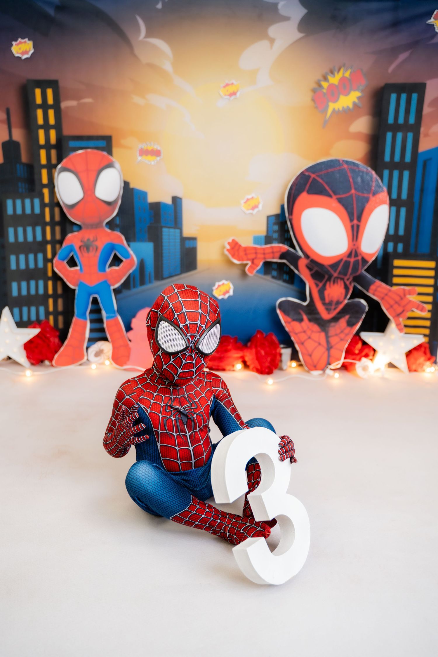 Metro Detroit children photographer Spider-Man themed birthday photo shoot with number one prop and city backdrop.