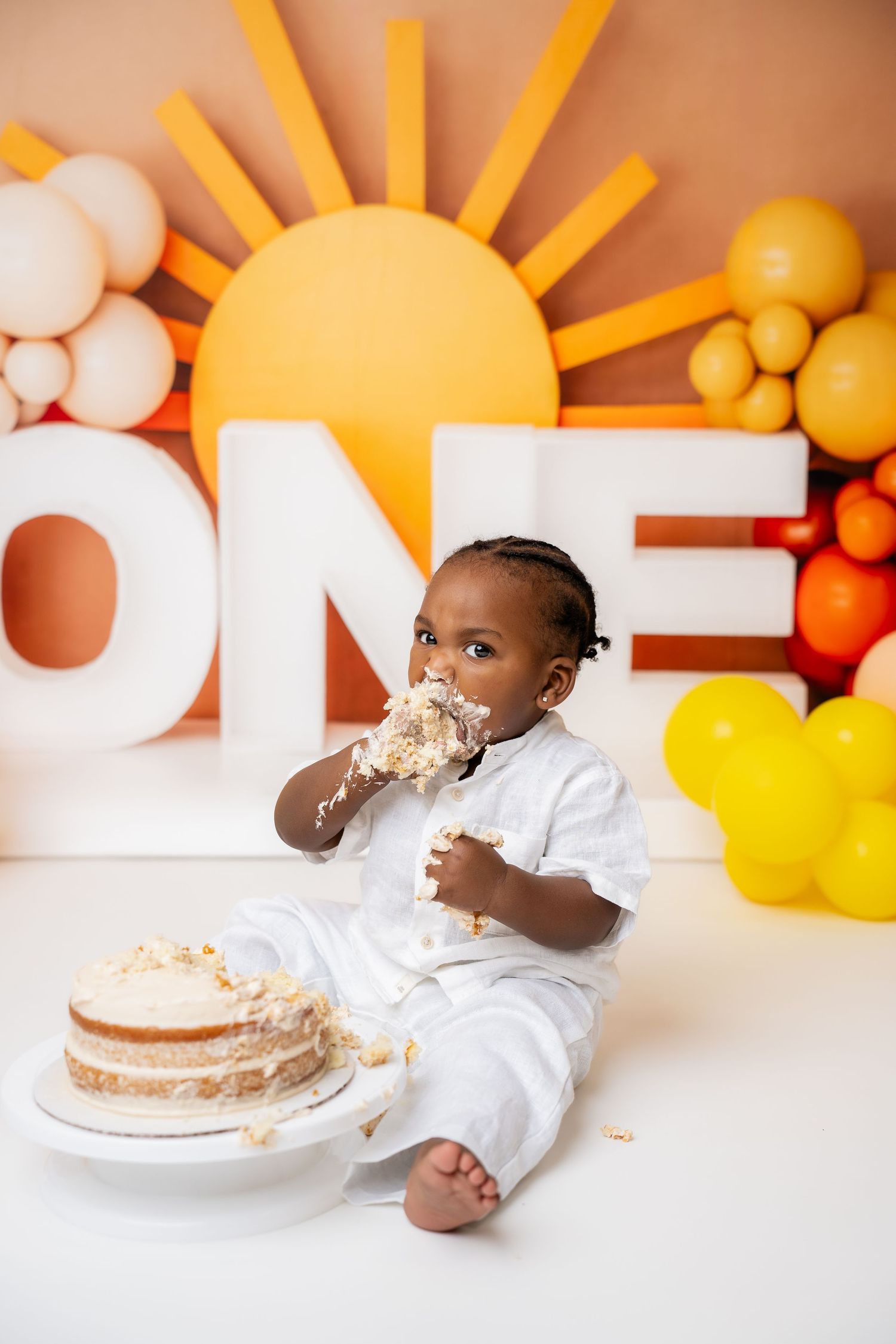 Metro Detroit children photographer Warm sunset-themed photo setup with orange and yellow balloons and sun rays on the wall.