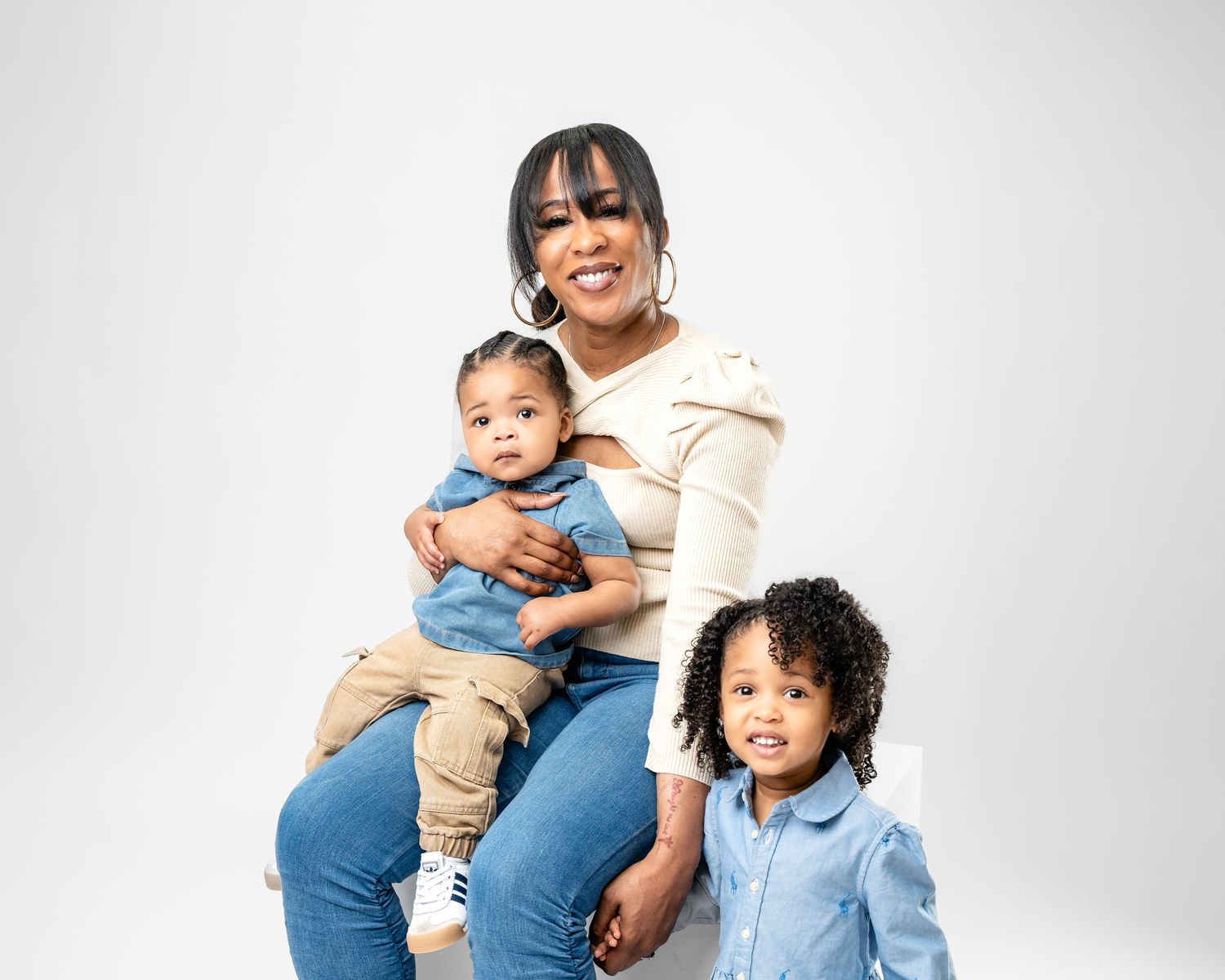Metro Detroit family photographer capturing  a Candid family moment in casual denim and neutral colored clothing.