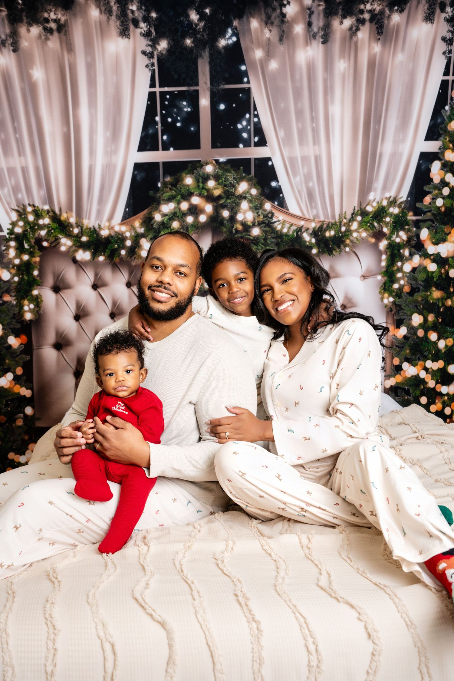 Metro Detroit family photographer capturing A family lounges together in matching white pajamas on a bed